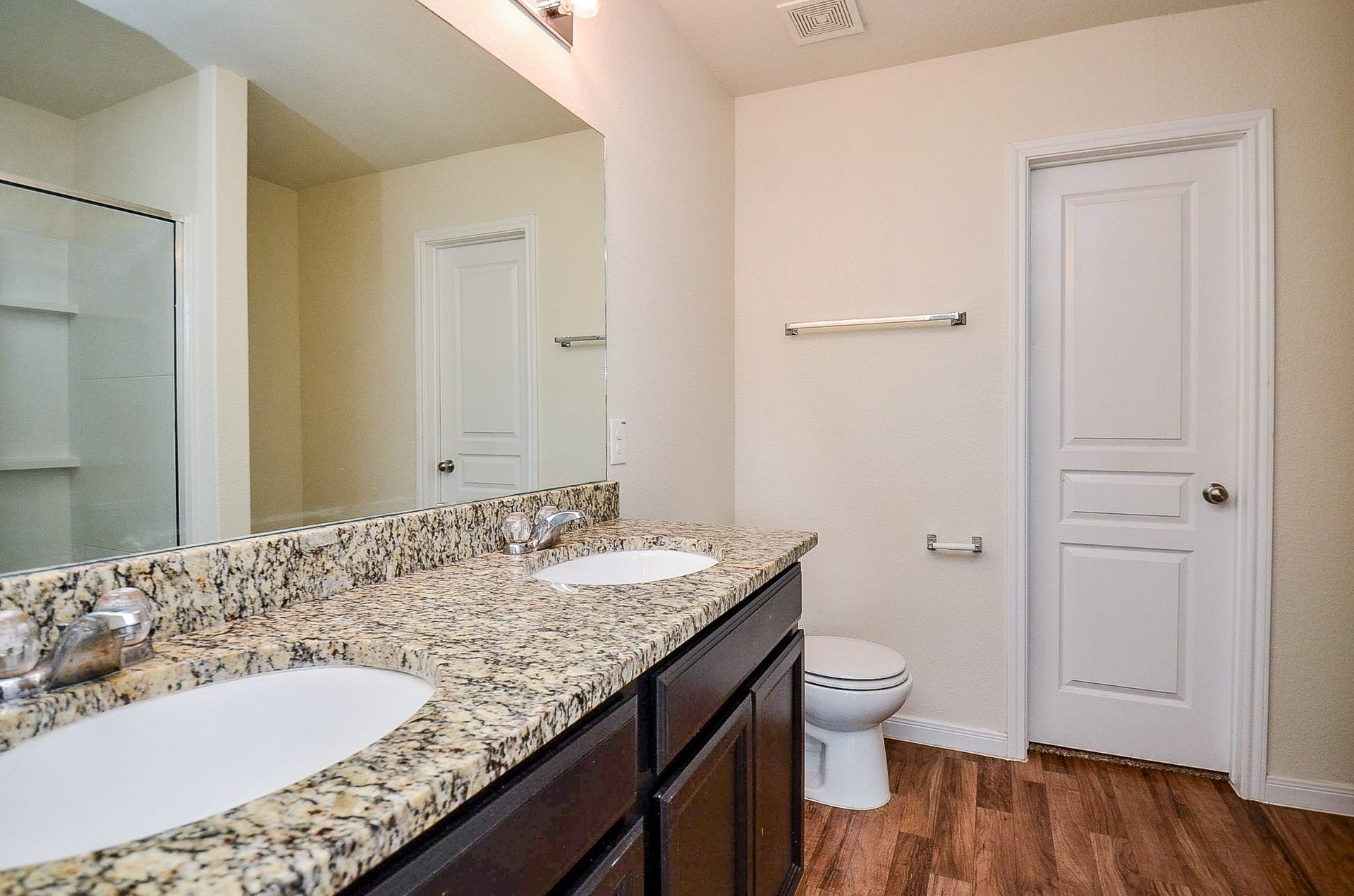 2539 Bedrock Lane, Missouri City, TX 77489 Elegant bathroom with a double vanity featuring granite countertops, sleek fixtures, and a spacious shower area, complemented by warm flooring.