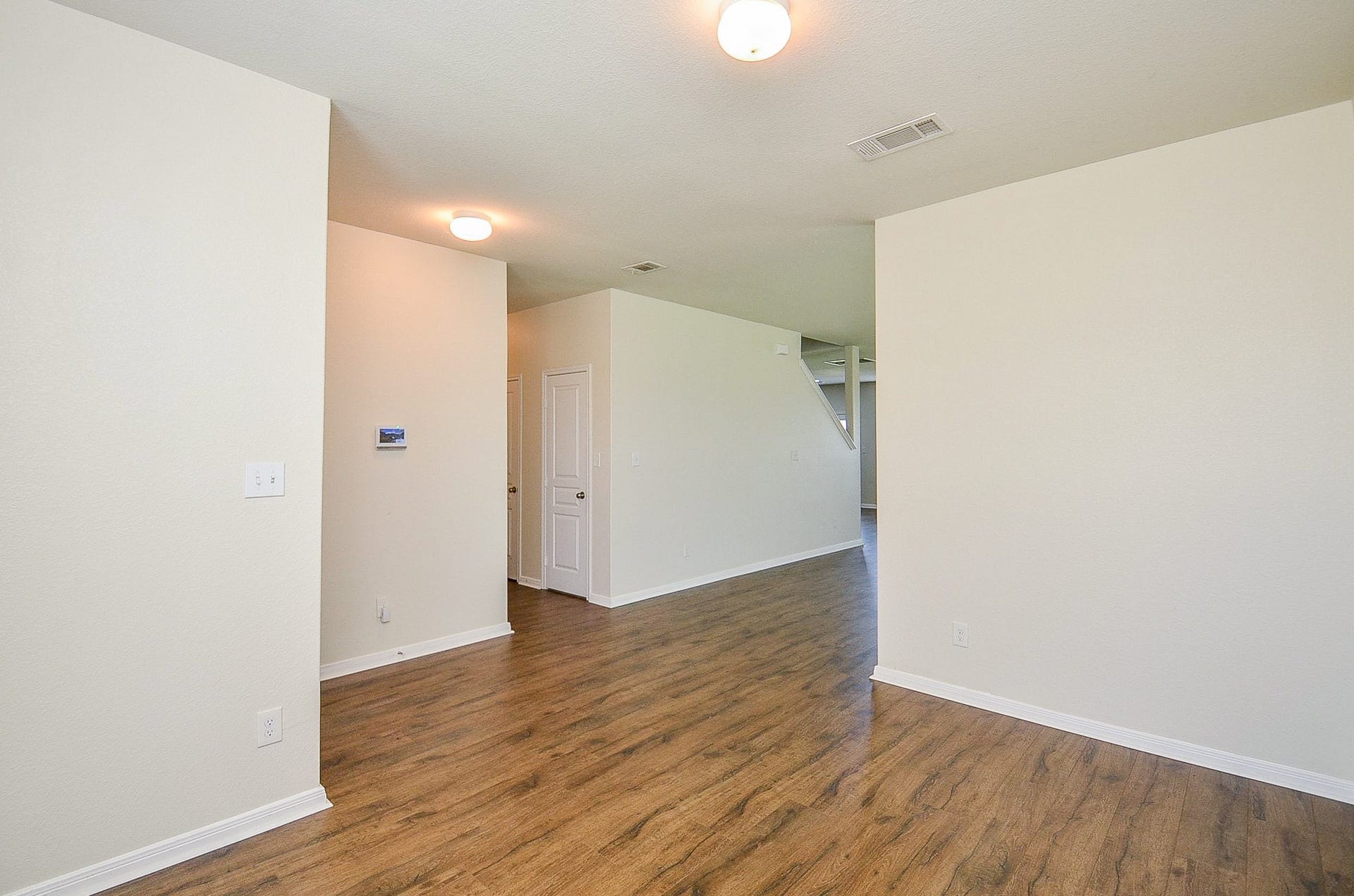 2539 Bedrock Lane, Missouri City, TX 77489 Spacious and inviting room with warm wood flooring and neutral walls, leading to an open living area.