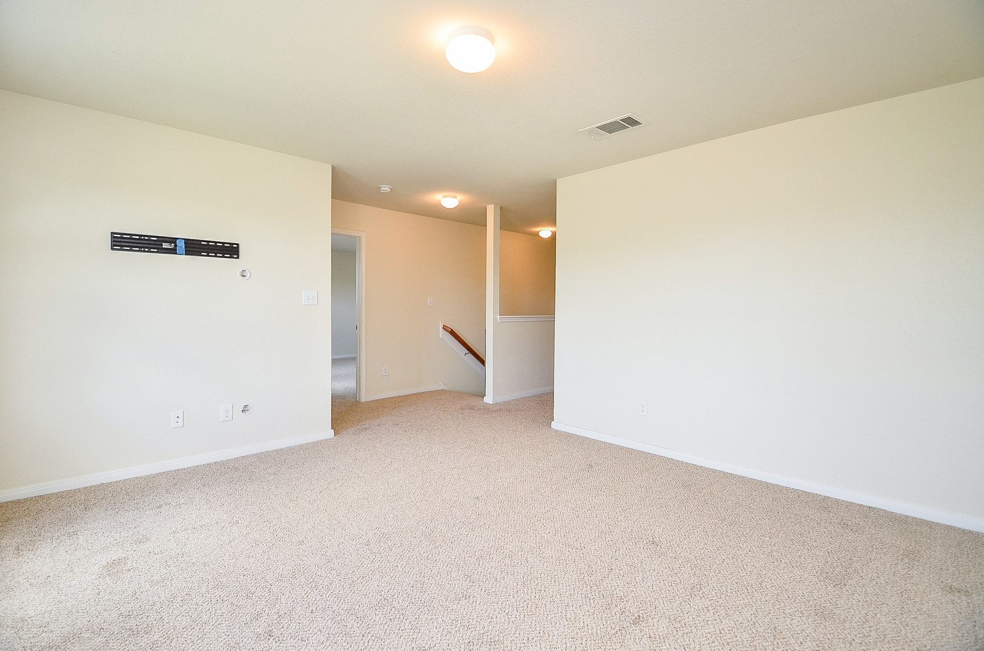 2539 Bedrock Lane, Missouri City, TX 77489 Spacious upstairs landing area with neutral carpeting and ample natural light, perfect for a cozy lounge or play area.
