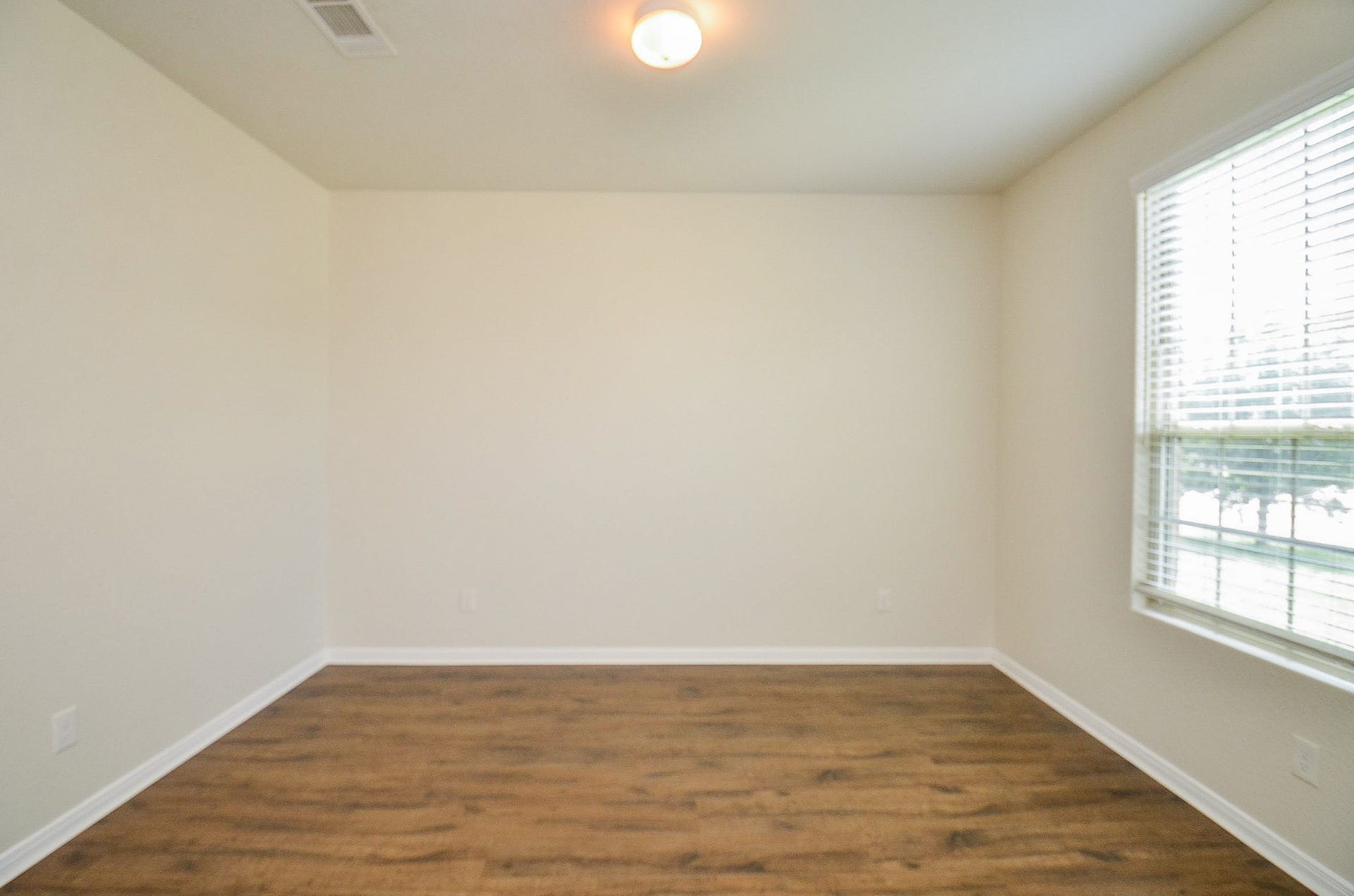 2539 Bedrock Lane, Missouri City, TX 77489 Bright and airy room featuring elegant wood flooring, soft neutral walls, and ample natural light from a large window.