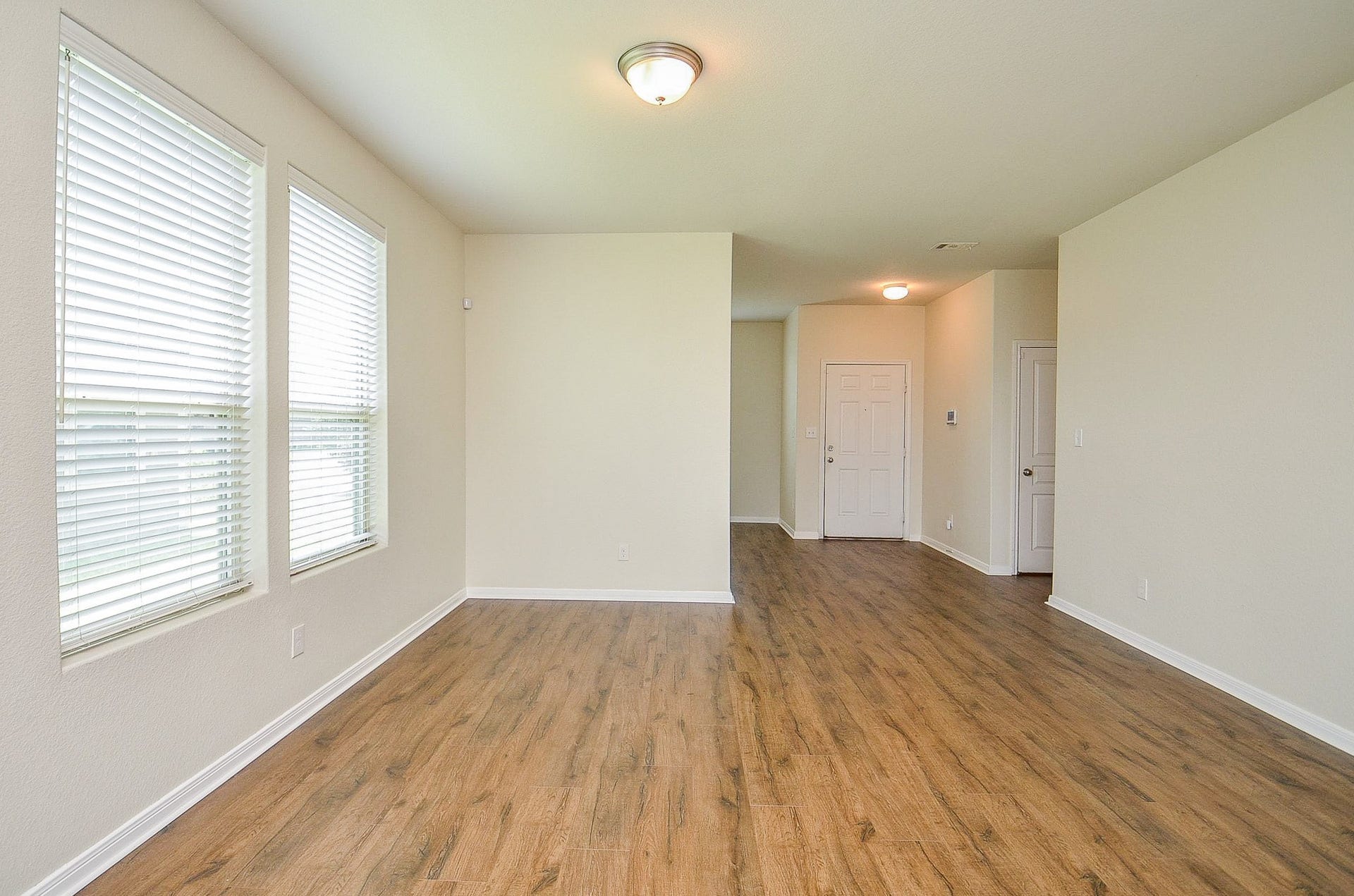 2539 Bedrock Lane, Missouri City, TX 77489 Bright and inviting entryway featuring warm wood flooring, neutral walls, and ample natural light from large windows.