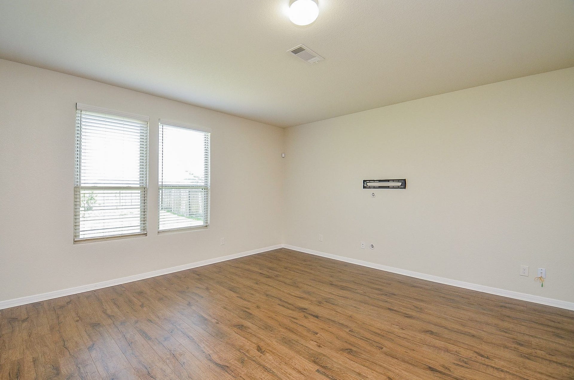 2539 Bedrock Lane, Missouri City, TX 77489 Spacious room with abundant natural light from large windows and elegant wood flooring, perfect for versatile living arrangements.