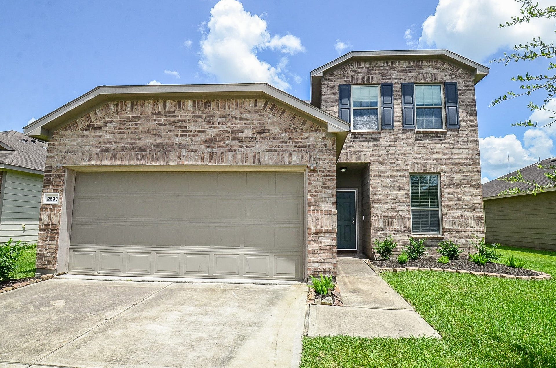 2539 Bedrock Lane, Missouri City, TX 77489 Two-story brick home with a spacious two-car garage and well-maintained front yard.
