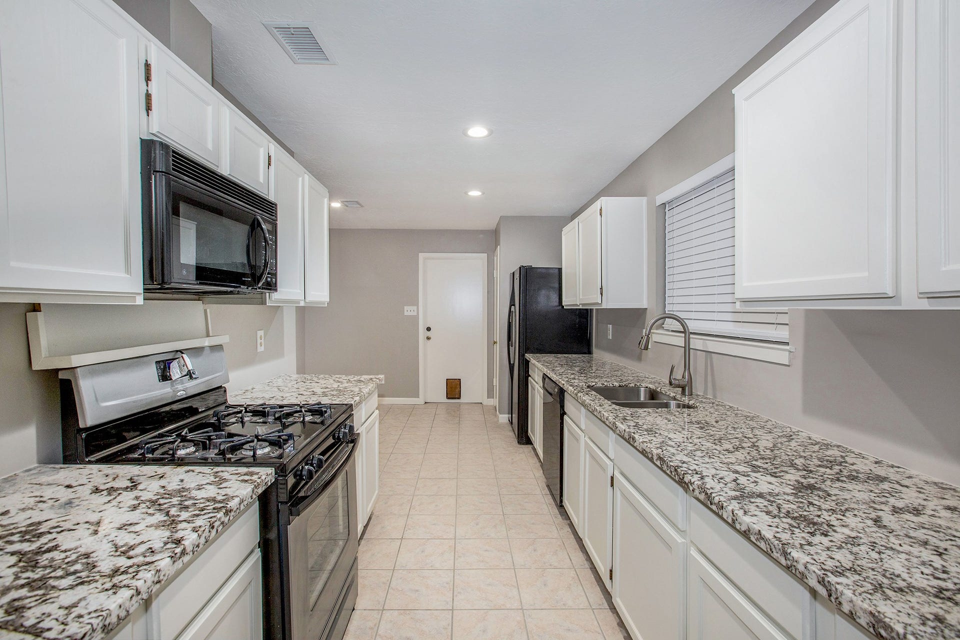 17002 Sky Blue Place, Houston, TX 77095 Great kitchen with gorgeous granite countertops, white cabinets, gas cooktop, stainless steel sink and faucet.