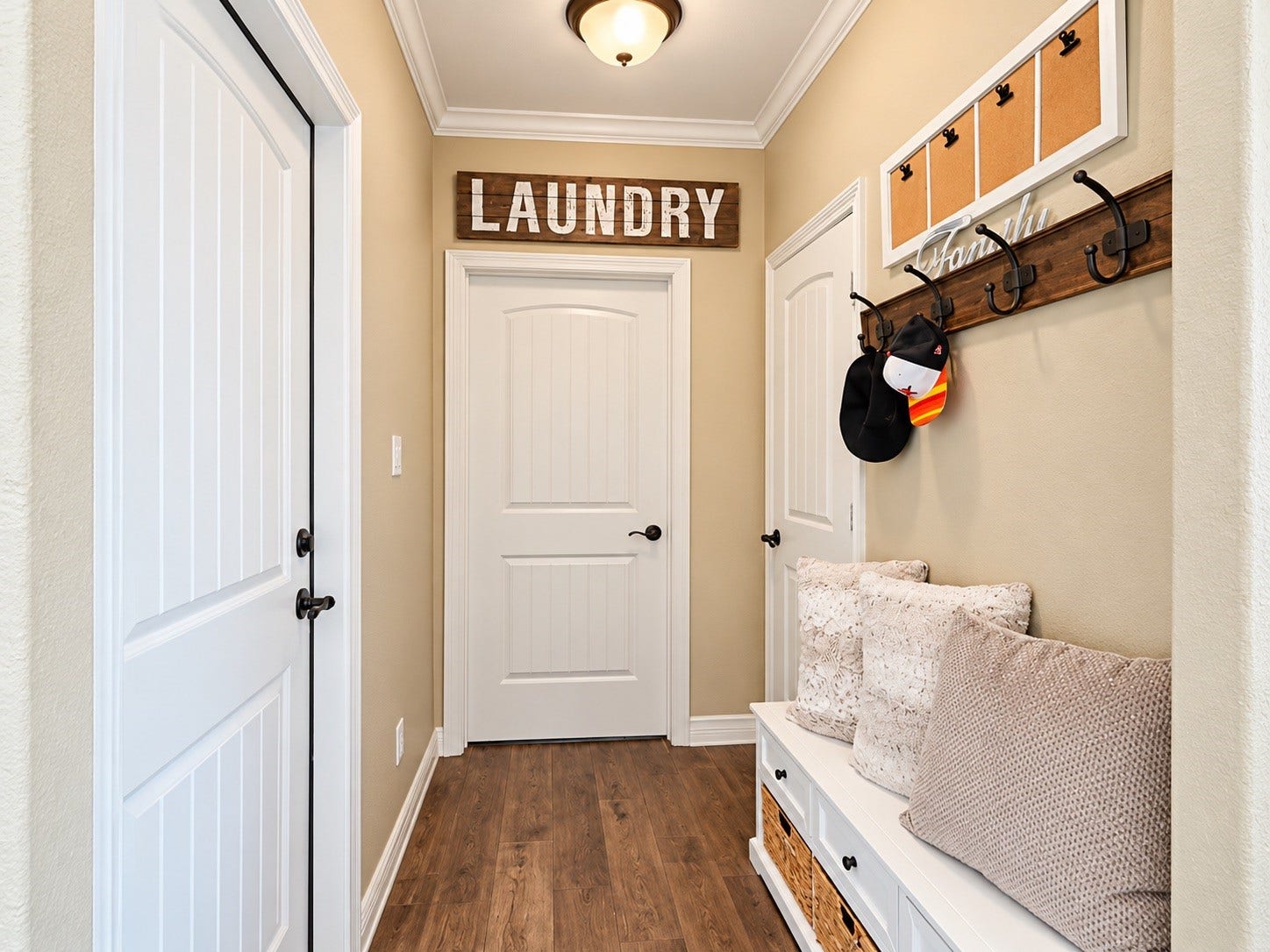 8999 Water Point Drive, Beach City, TX 77523 Charming mudroom featuring a cozy bench with storage baskets, wall hooks for convenience, and an inviting entry to the laundry area.