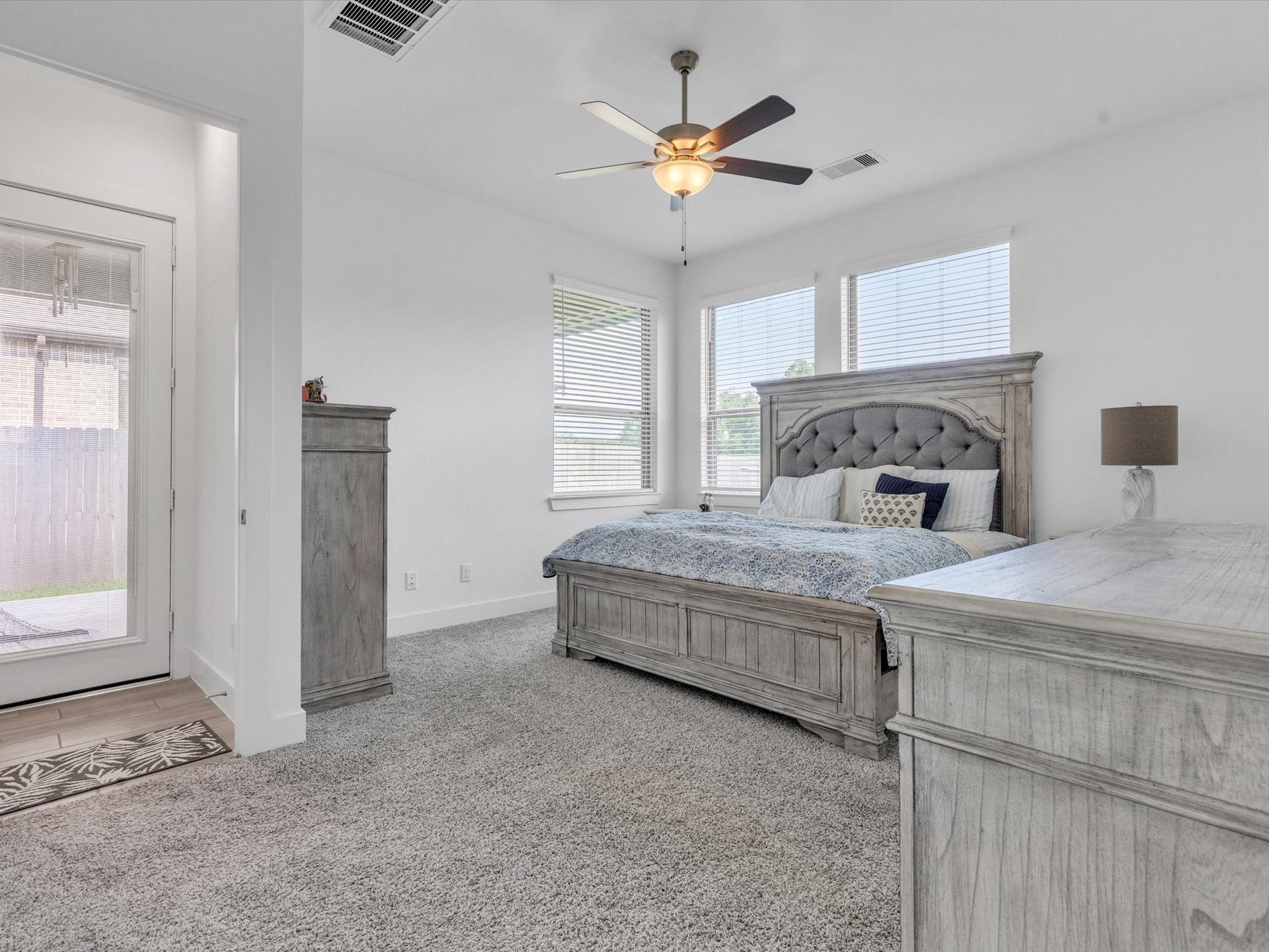 10718 Hidden Rock Drive, Missouri City, TX 77459 The first-floor primary suite offers a spacious, private retreat with abundant natural light and direct access to the covered patio and backyard.