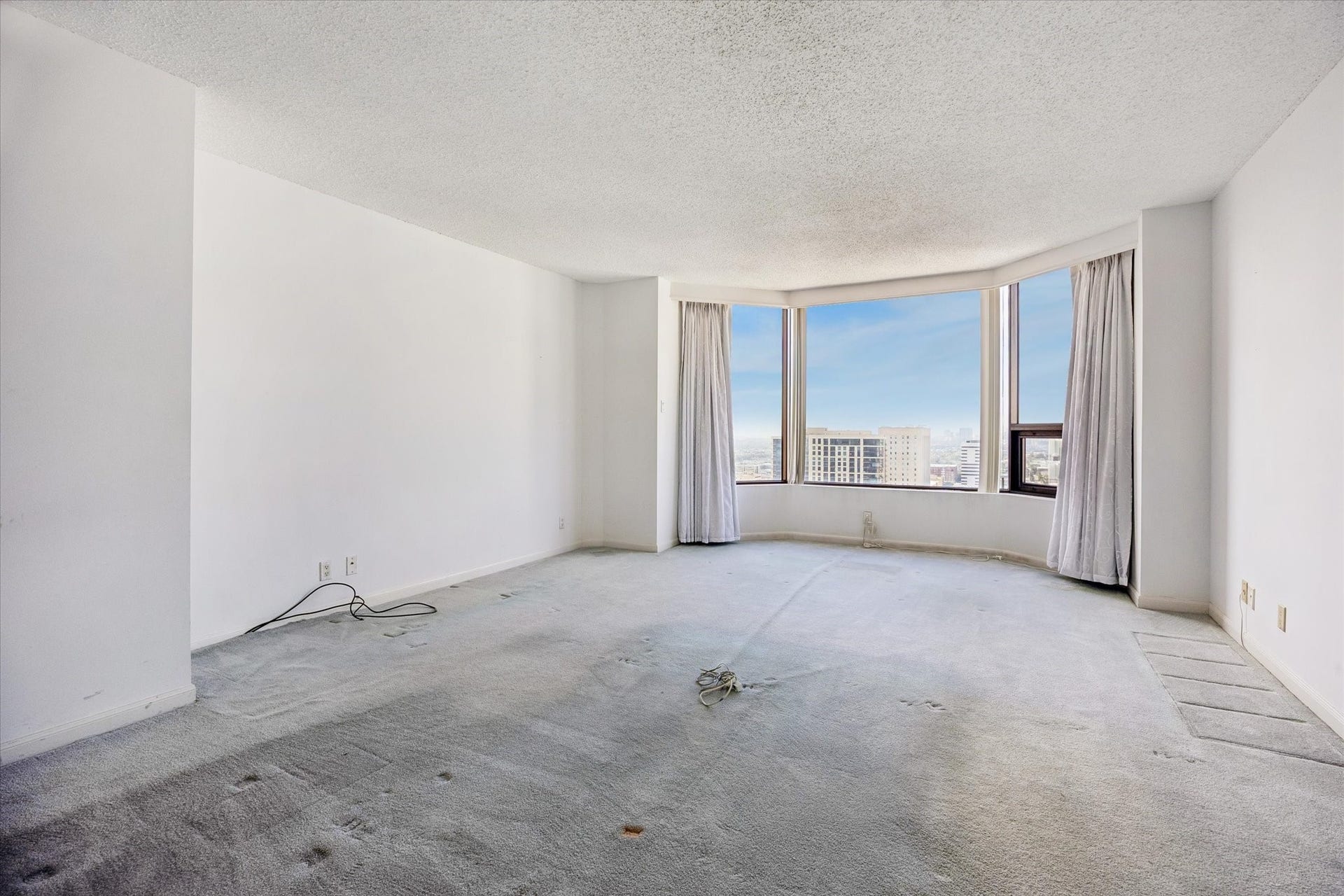 1111 Caroline Street, #2606, Houston, TX 77010 Bay windows frame city views, with neutral walls and carpeted flooring providing a soft backdrop. Open floor space allows you to shape a comfortable den with your own colors and personal touches.