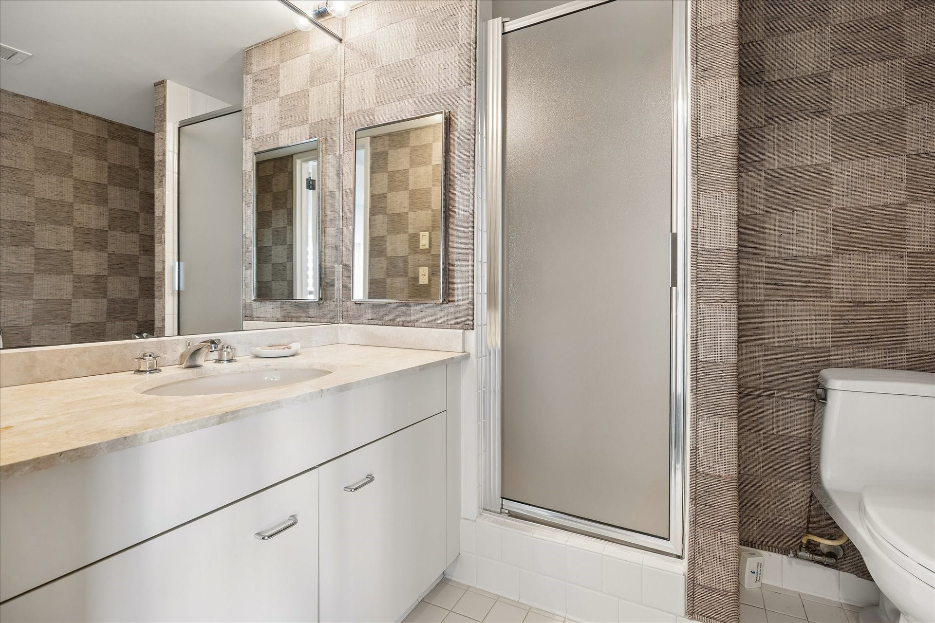 1111 Caroline Street, #2606, Houston, TX 77010 Wide vanity counters and drawers provide practical space for daily routines and bathroom storage. A mirrored wall and frosted glass shower enclosure complete this bath, one of 3 in the residence.
