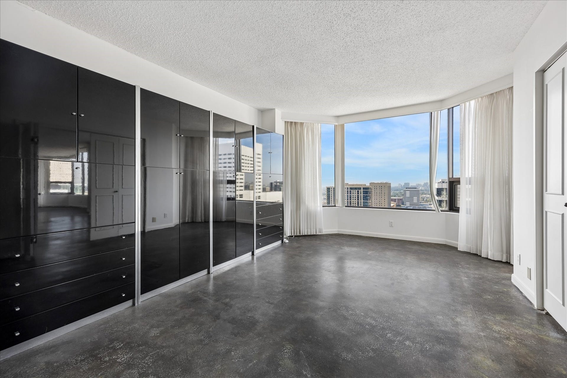 1111 Caroline Street, #2606, Houston, TX 77010 Double doors allow this flexible room to open to the adjoining living area or close for added separation. Concrete flooring and a broad window bay make it well suited for a study, reading room or additional living space.