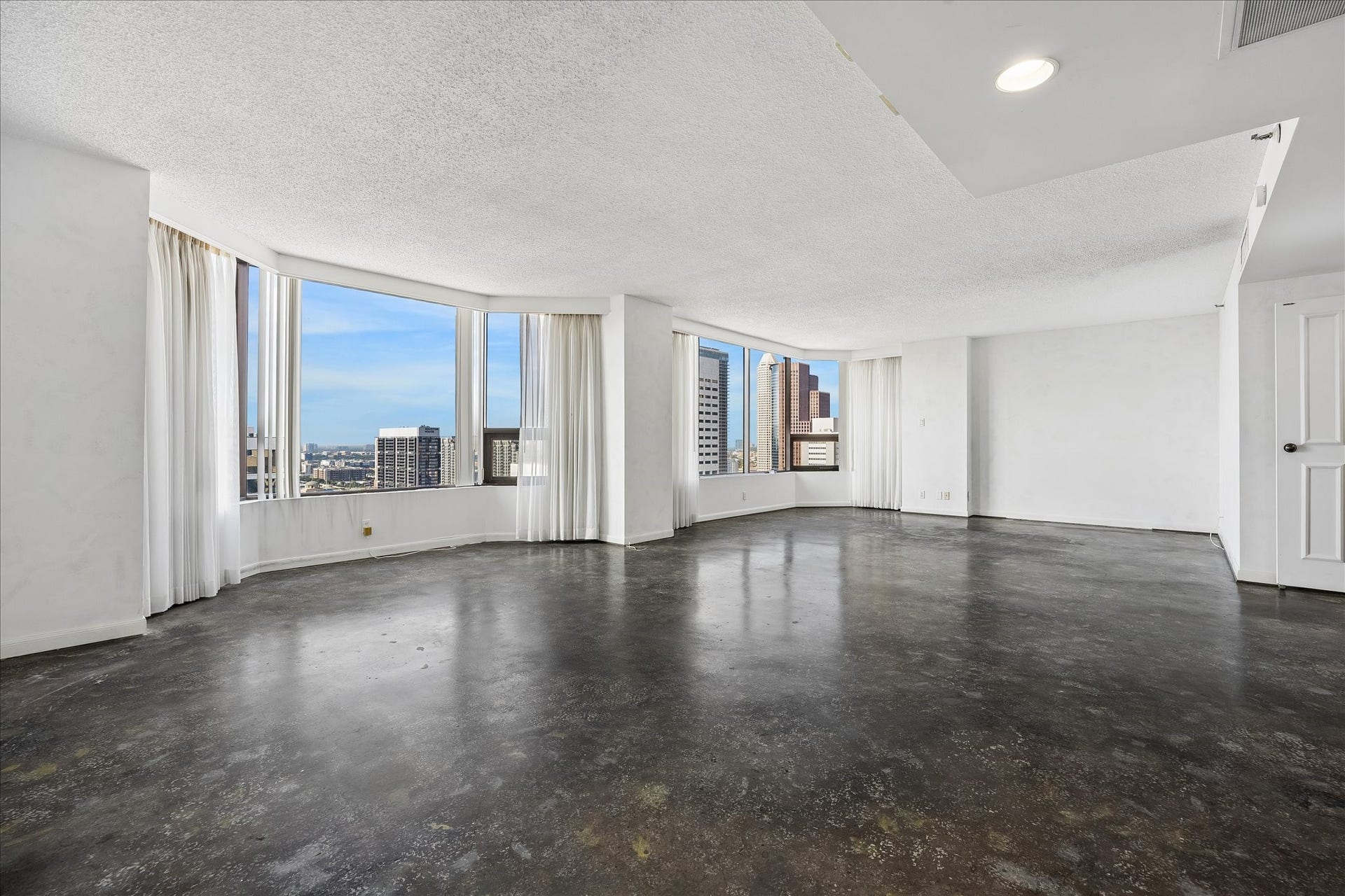 1111 Caroline Street, #2606, Houston, TX 77010 Broad window bays frame downtown views and fill the living area with natural light. Dark concrete flooring and neutral walls create a blank slate for your personal touches, with open space to shape around the way you live.