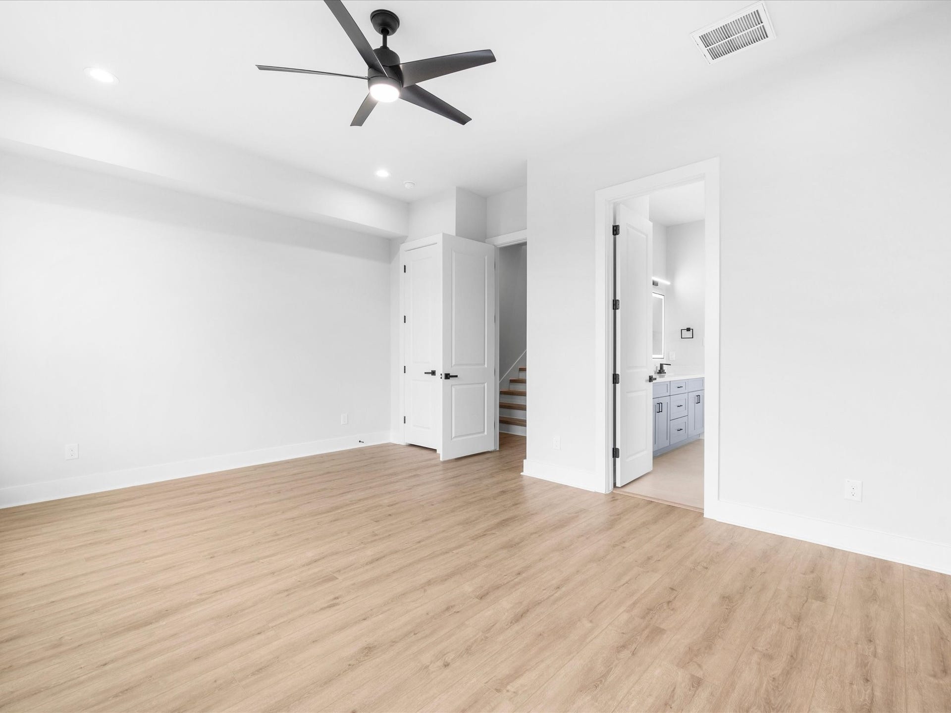 A clean, modern aesthetic and natural light create a relaxing atmosphere in the primary bedroom, offering a welcome place to unwind at the end of the day.