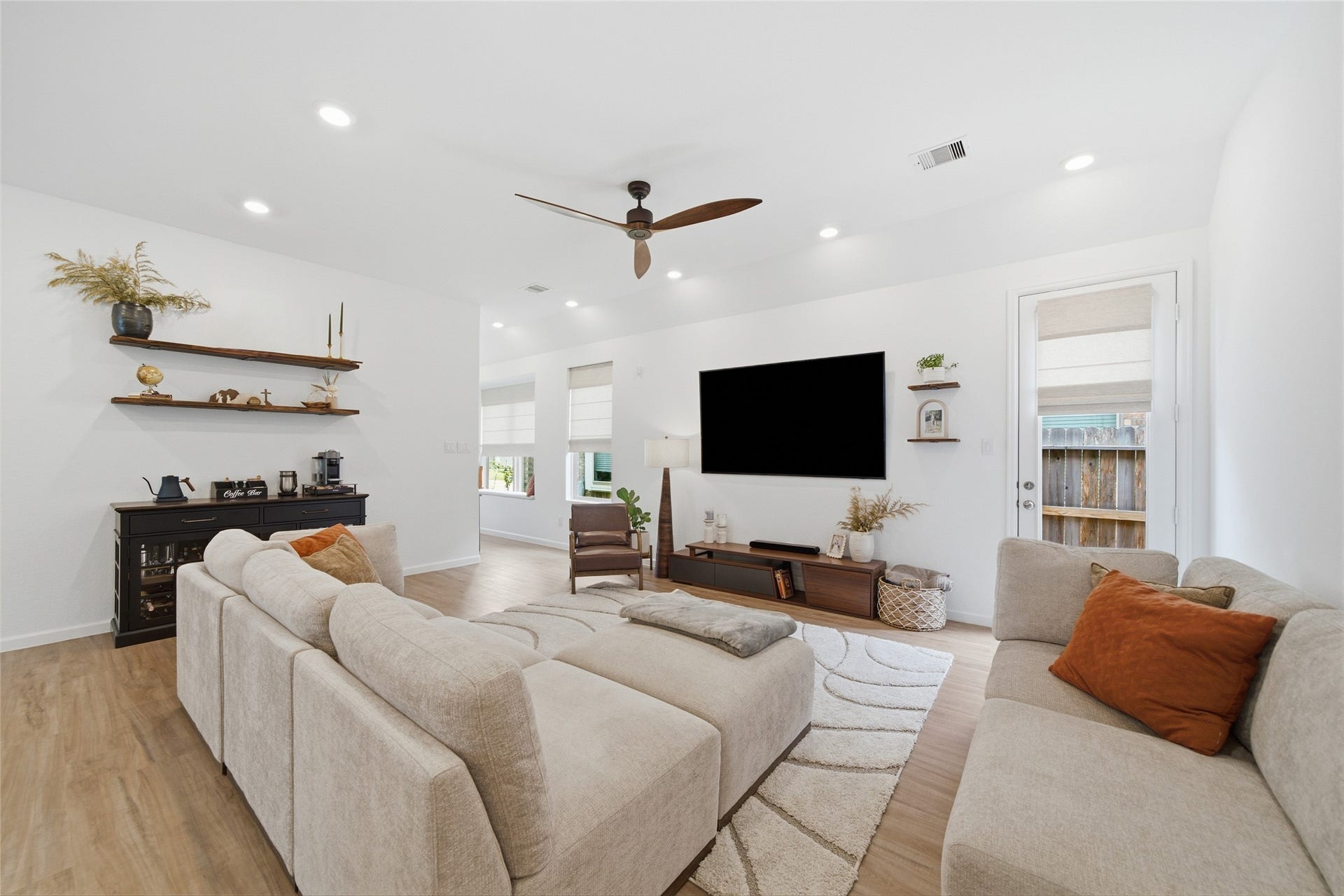 4919 Sand Clouds Drive, Katy, TX 77493 The large windows with custom shades, create a warm bright feel. The wood look flooring continues throughout the main area of the home.