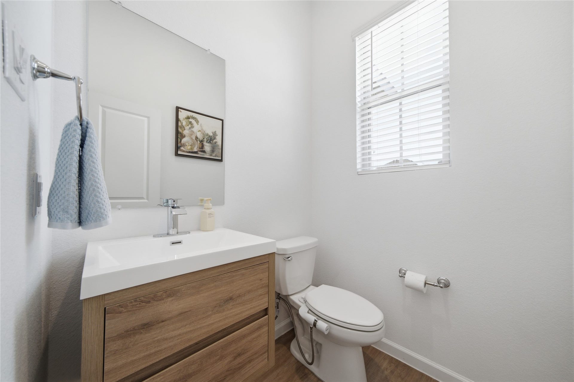 4919 Sand Clouds Drive, Katy, TX 77493 Half bath with wooden vanity and wood look flooring. Conveniently located for guest use.