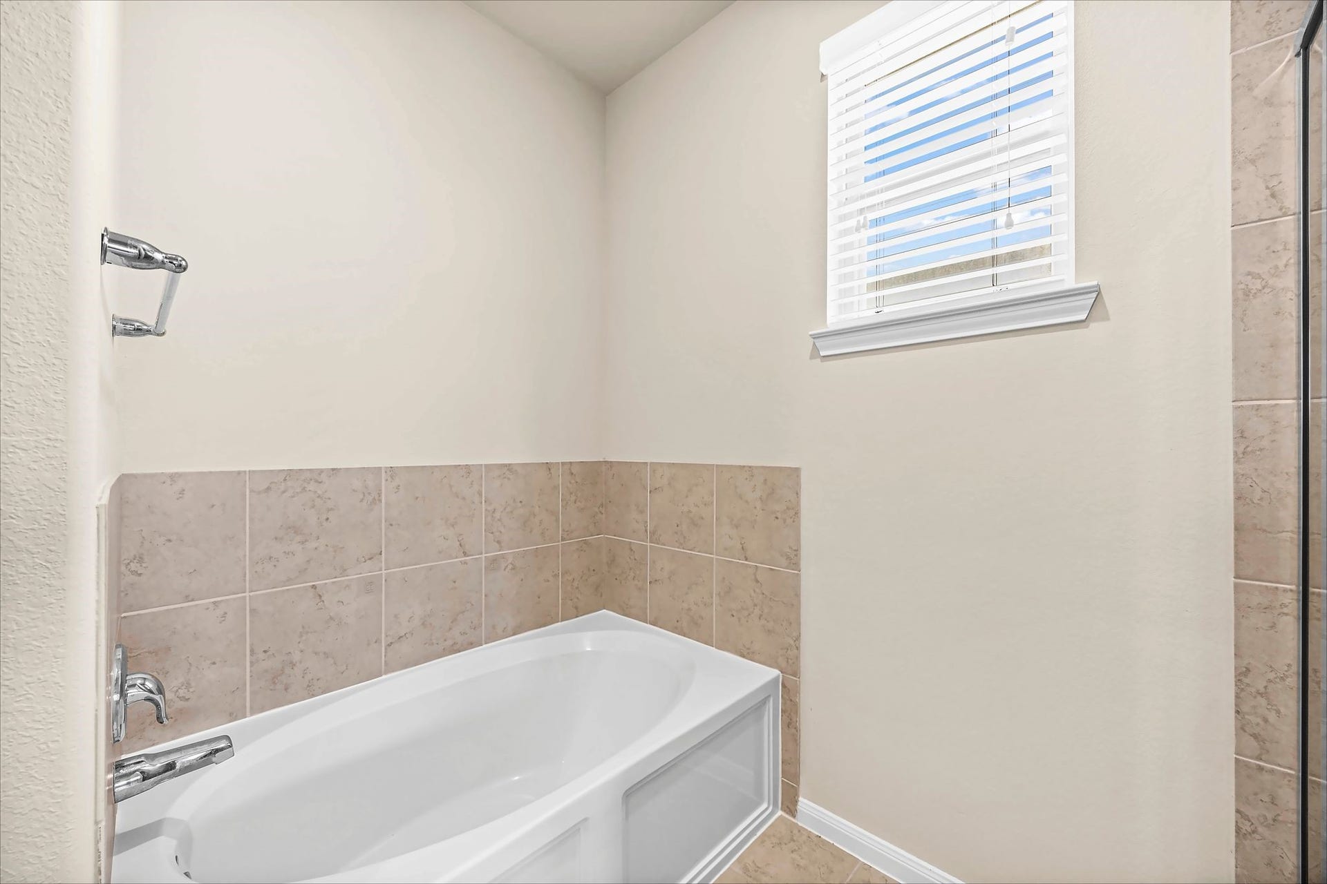 Slow down and enjoy a relaxing soak in the primary bath, complete with a tiled tub surround and window.