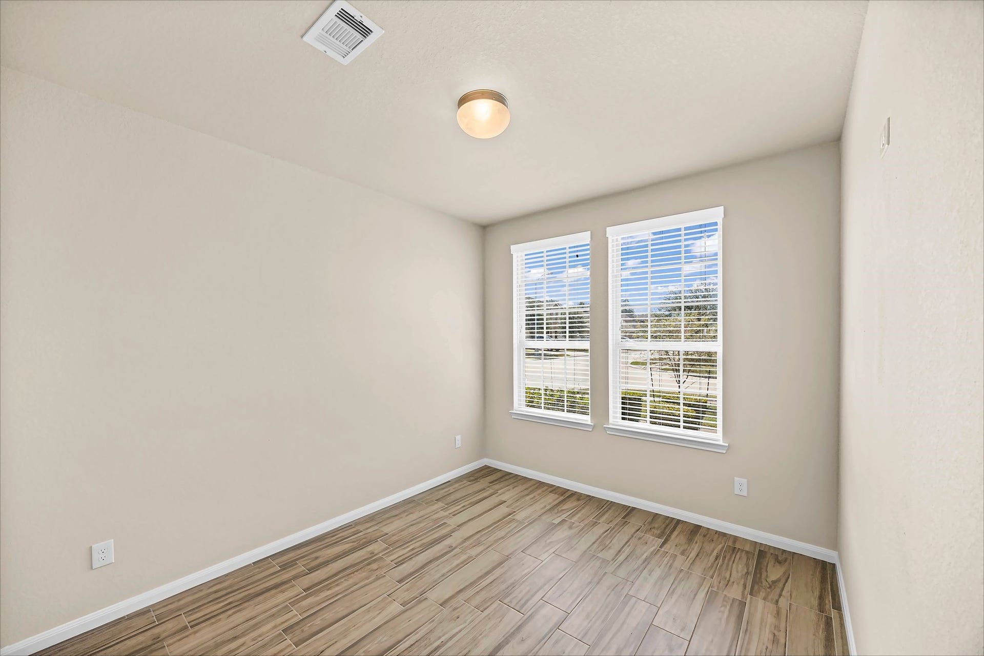 A bright, inviting secondary bedroom with tile flooring offers a comfortable place to make your own.