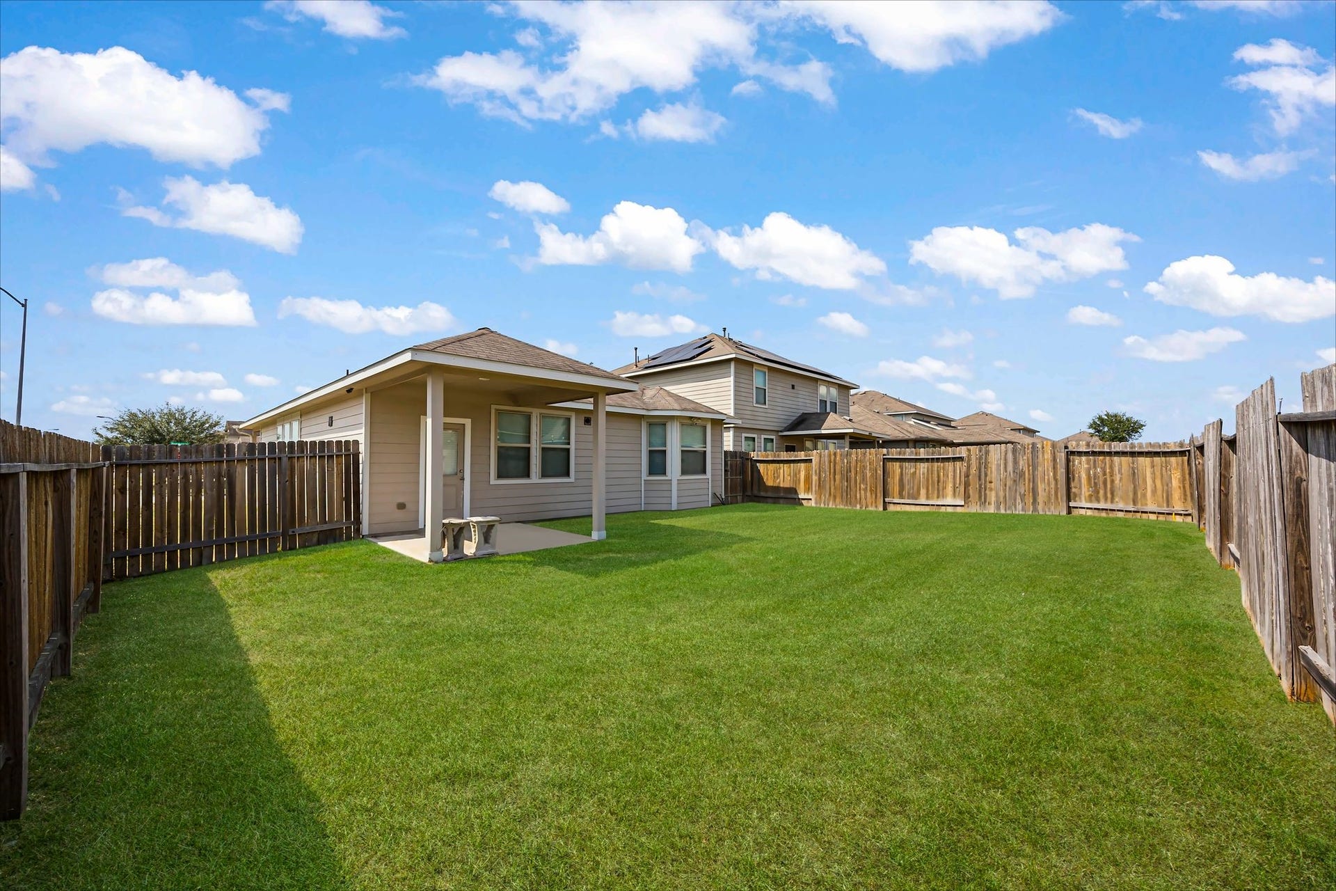 Step outside and enjoy a fenced backyard with green lawn for fresh air and relaxed afternoons.