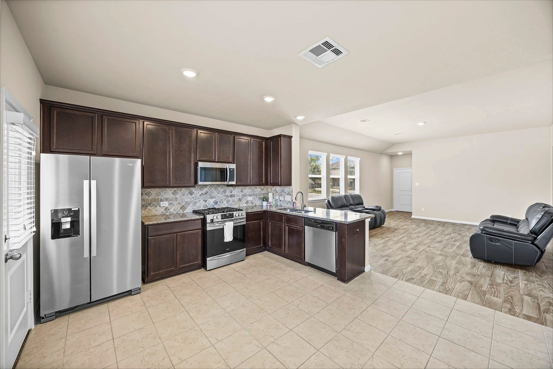 The heart of the home features rich dark cabinetry and a welcoming breakfast bar. The refrigerator may come included with the purchase of this home.