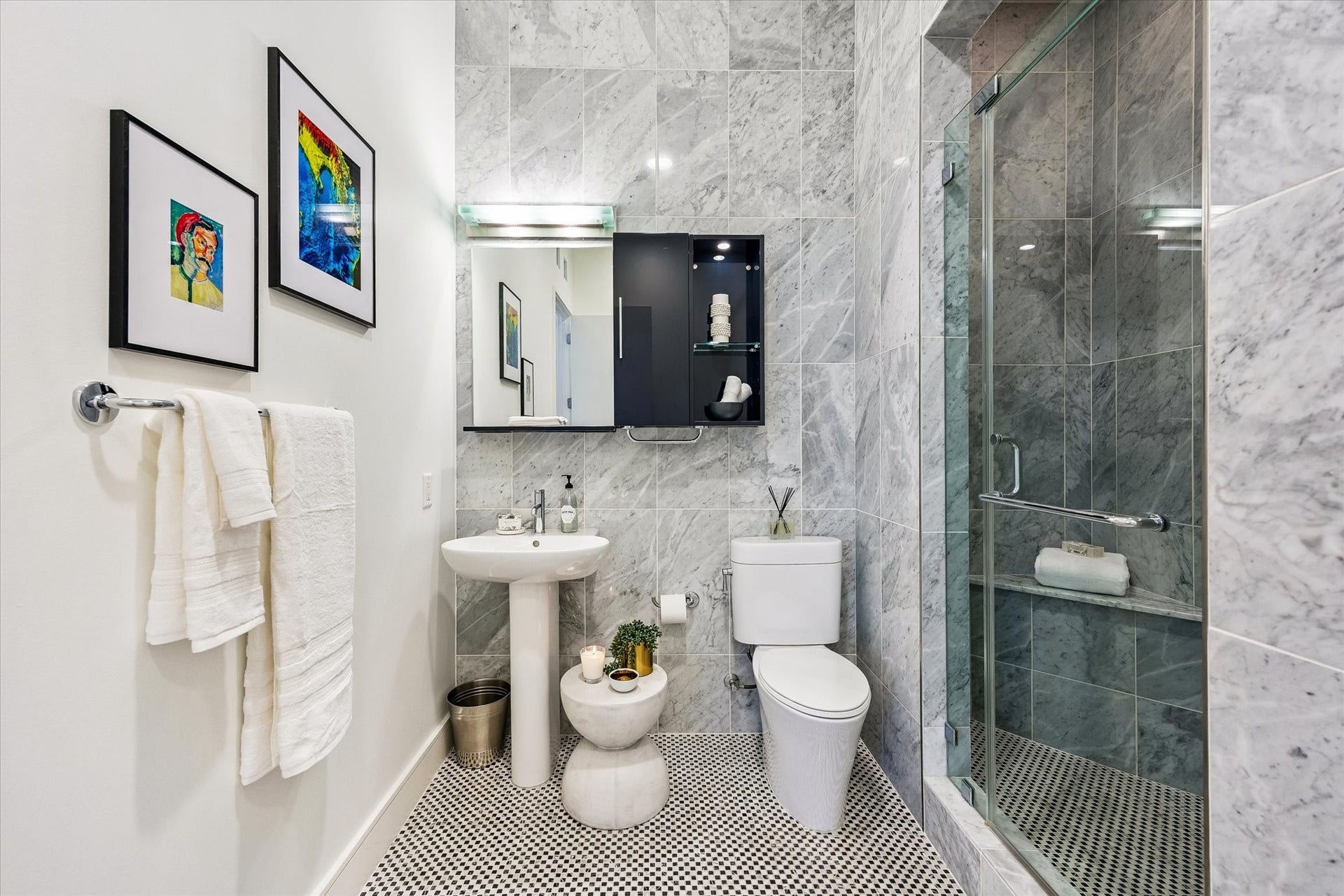 [Bathroom Three] Marble-clad bathroom with walk-in shower. This also serves as the powder/guest bathroom.