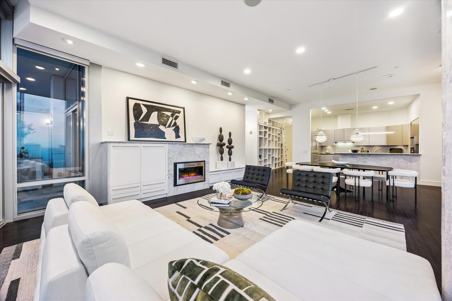 2727 Kirby Drive, #13E, Houston, TX 77098 Marble-clad fireplace, custom built-ins, and glass opening to a private terrace with city views.