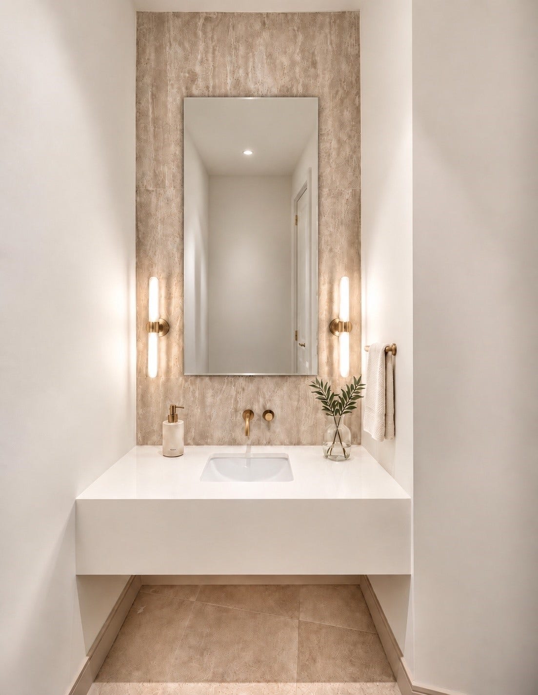 One of the three beautifully appionted half-baths, thi intimate jewel box pairs sculptural simplicity with understate glamour, where softly veined, warm brass sccents and luminous lighting turn a practical space into a moment of pure elegance.