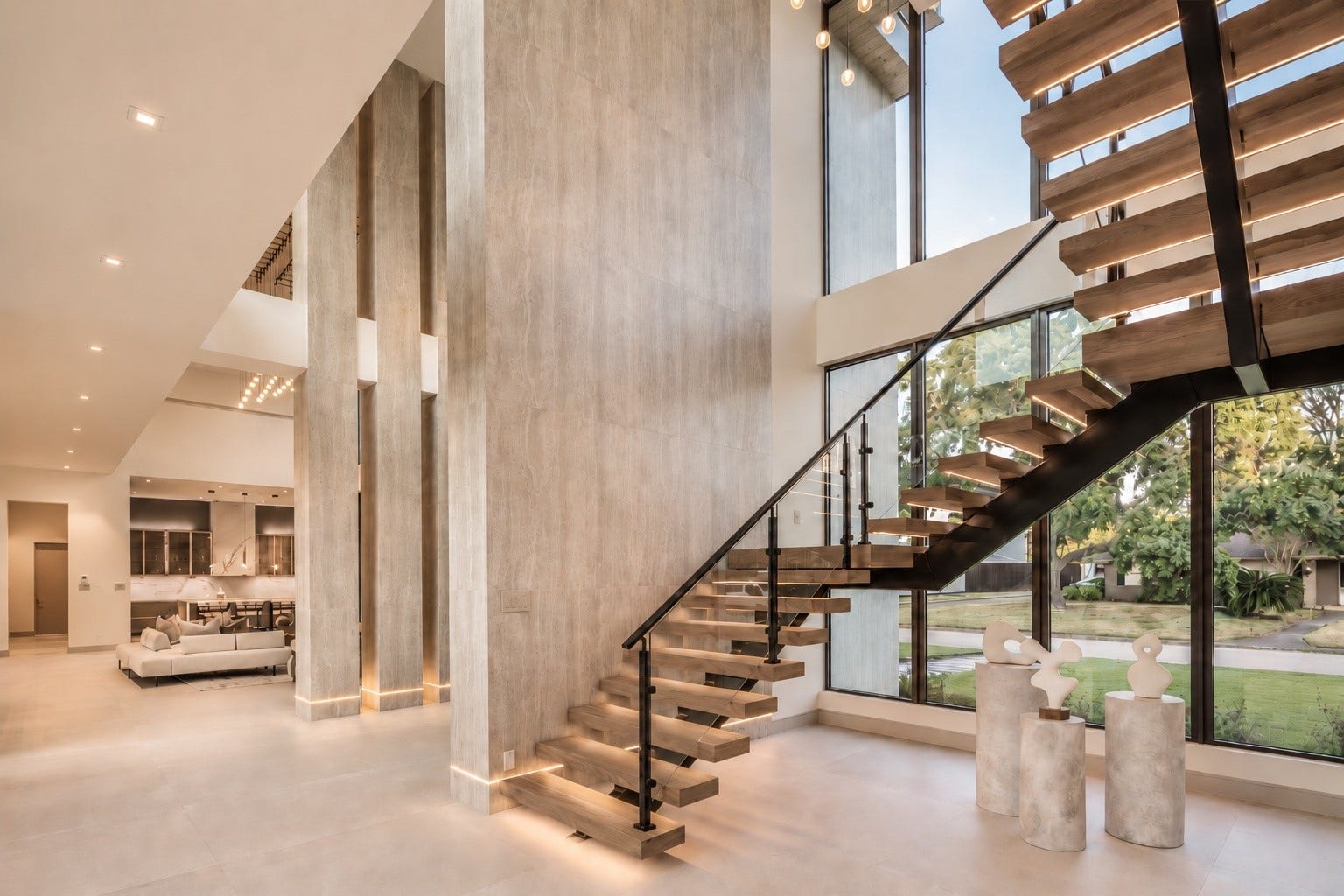 Dramatic double -height entry makes a striking first impression, highlighted by soaring architectural walls, floor-to-ceiling glass and sculptural floating staircase with warm integrated lighting. Clean modern palette and curated art creat a sophisiticated, gallery-like arrival.