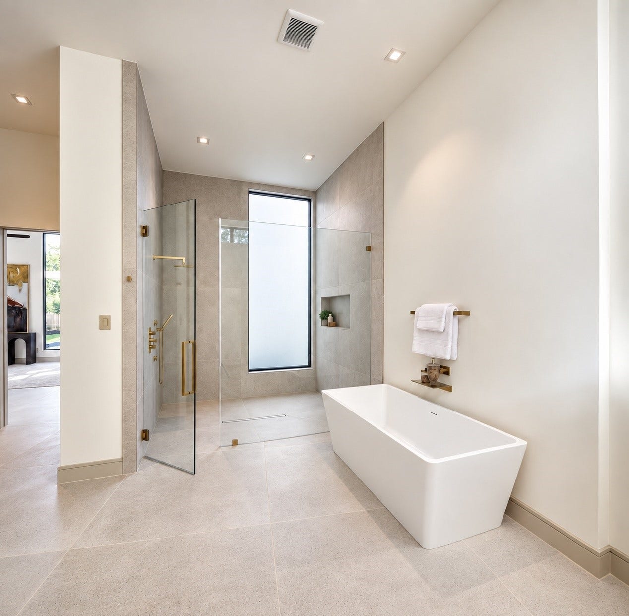 More than a bath, this primary retreat feels like a private spa escape. A soaking tub invites youto linger, while the oversized walk-in shower delivers a resort-style inspired  experience wrapped in soft stone, warm brass and natural light.