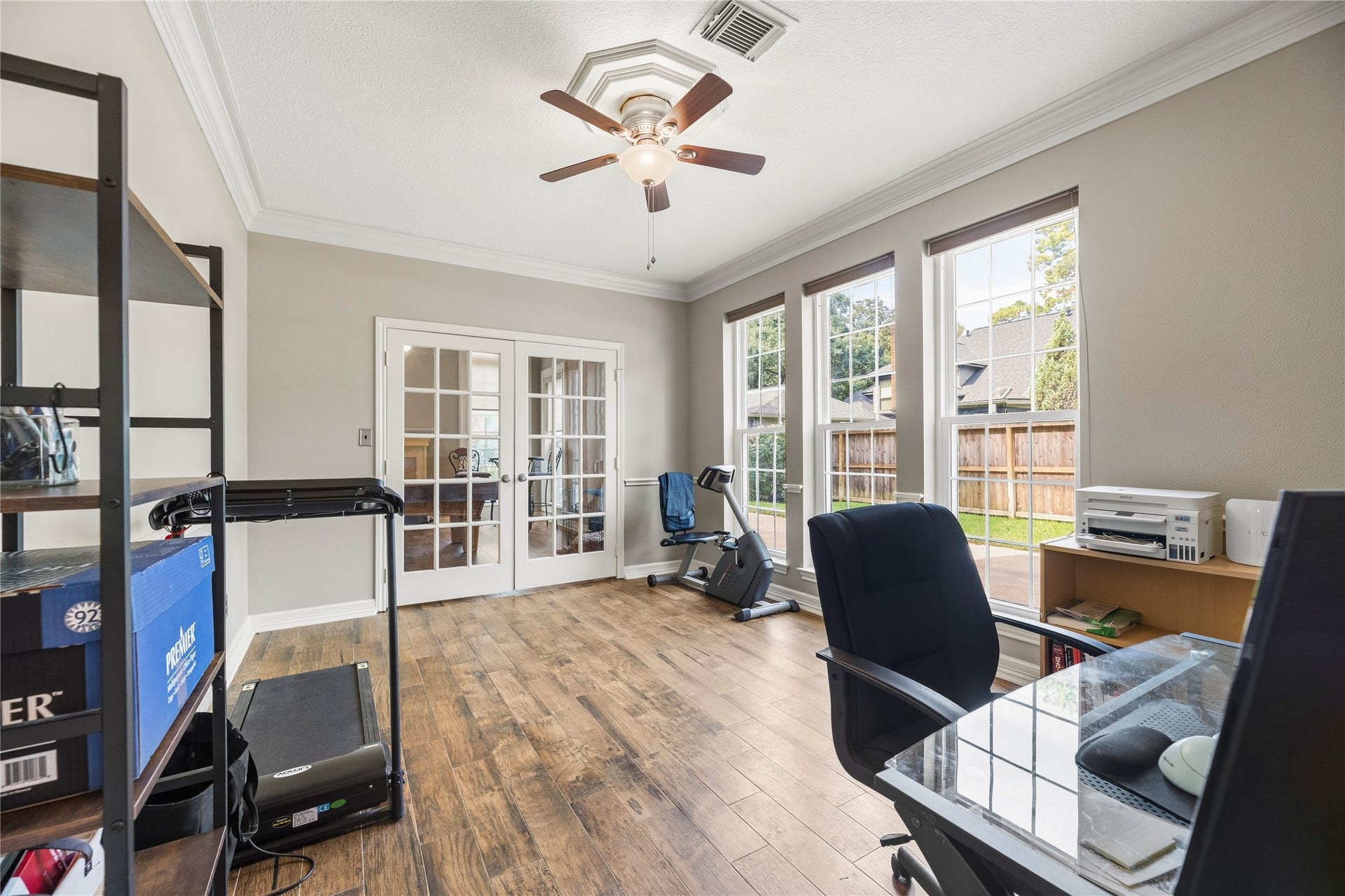 13114 S Winesap Lane, Cypress, TX 77429 Bright and versatile dining room, currently used as an office with large windows, elegant French doors, and warm wood flooring, perfect for entertaining, productivity and inspiration.