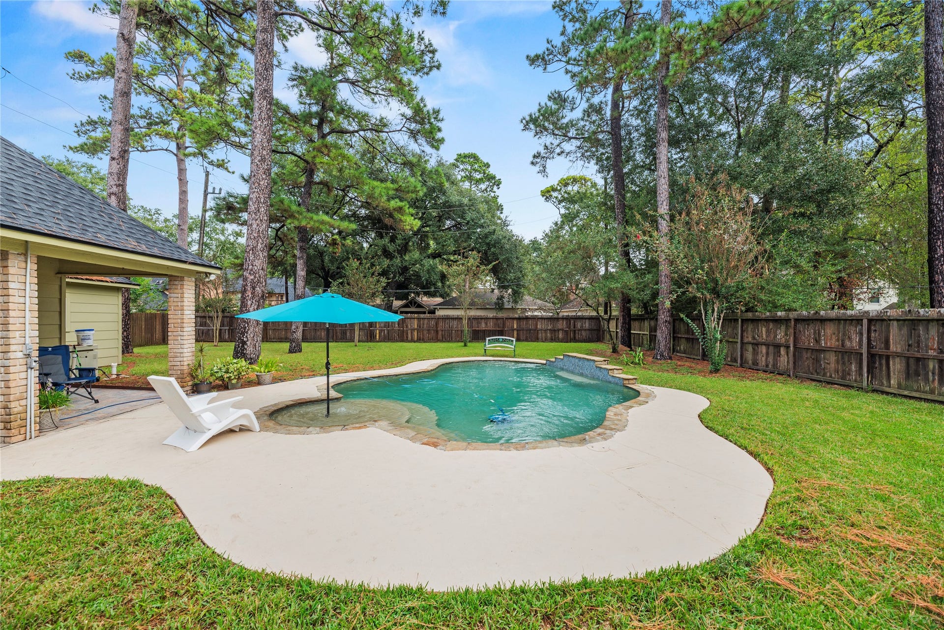 13114 S Winesap Lane, Cypress, TX 77429 Inviting backyard oasis with a sparkling pool, surrounded by lush greenery and tall trees, perfect for relaxation and outdoor entertaining.