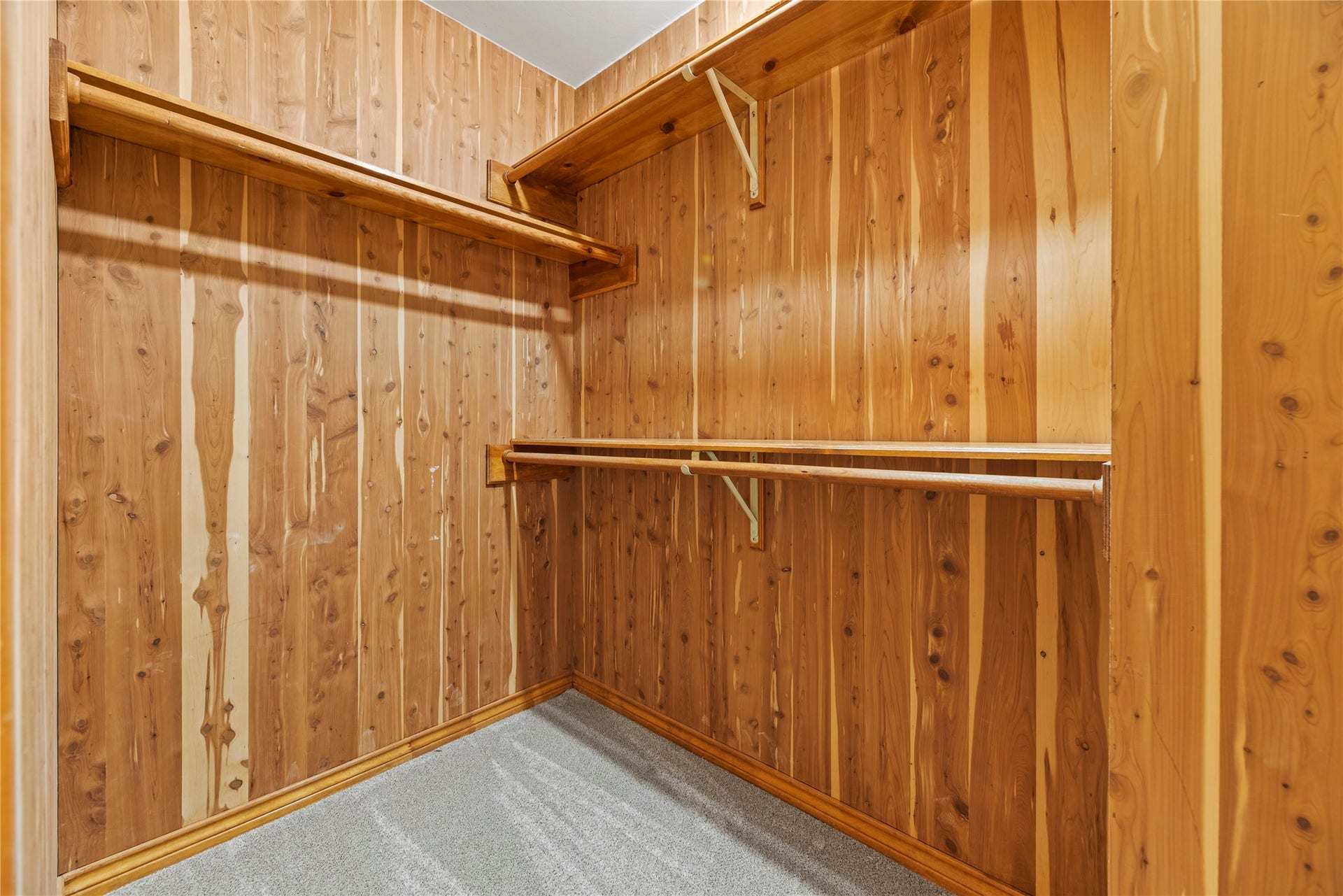 13114 S Winesap Lane, Cypress, TX 77429 Spacious cedar-lined walk-in closet with ample hanging space and a cozy, carpeted floor.