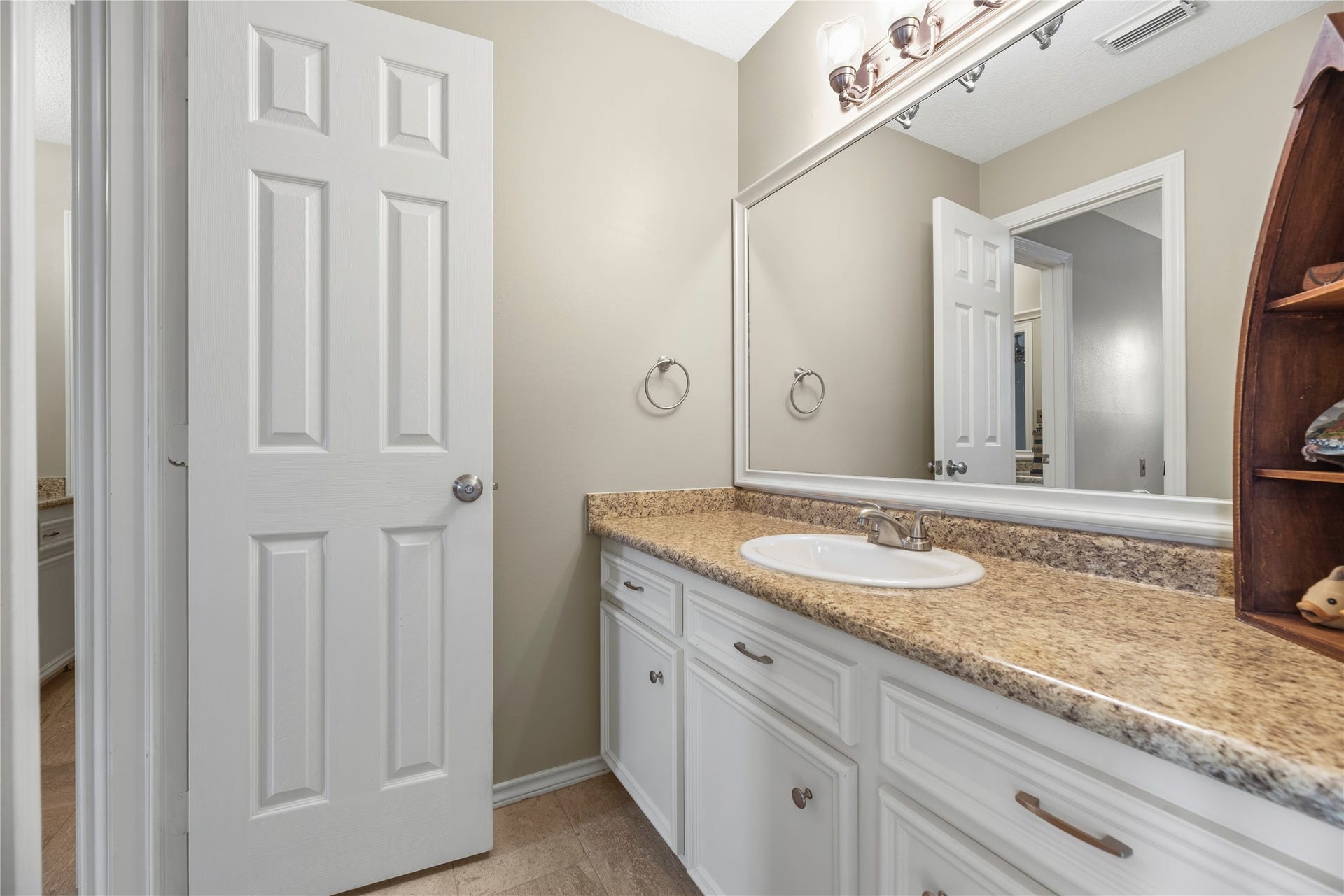 13114 S Winesap Lane, Cypress, TX 77429 Jack & Jill bathroom featuring a spacious granite countertop, large mirror, and ample cabinet storage beneath attached to secondary bedroom.