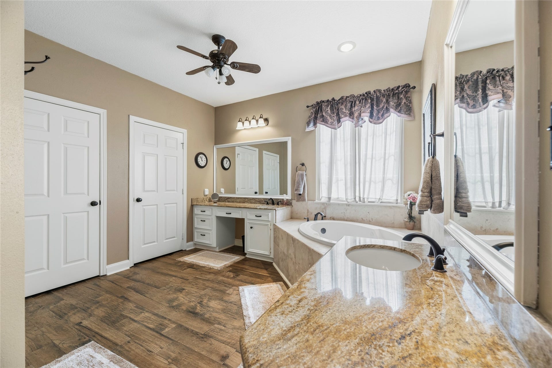 13114 S Winesap Lane, Cypress, TX 77429 Elegant primary bathroom featuring a luxurious soaking tub, glass enclosed shower, dual sinks with granite countertops, 2 walk in closets and ample natural light through large windows.