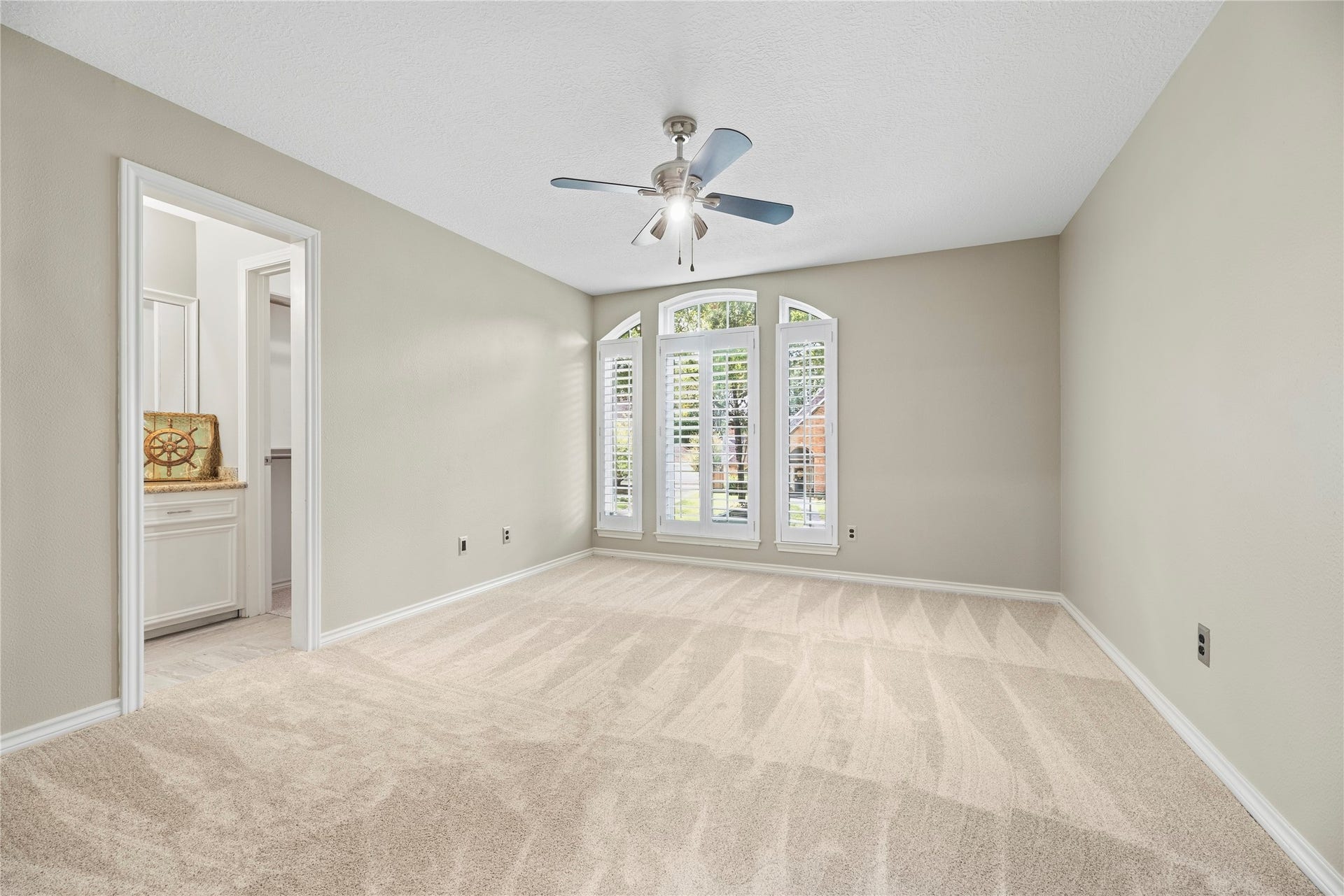13114 S Winesap Lane, Cypress, TX 77429 Spacious secondary bedroom featuring plush carpeting, a ceiling fan, and large windows with plantation shutters for ample natural light.