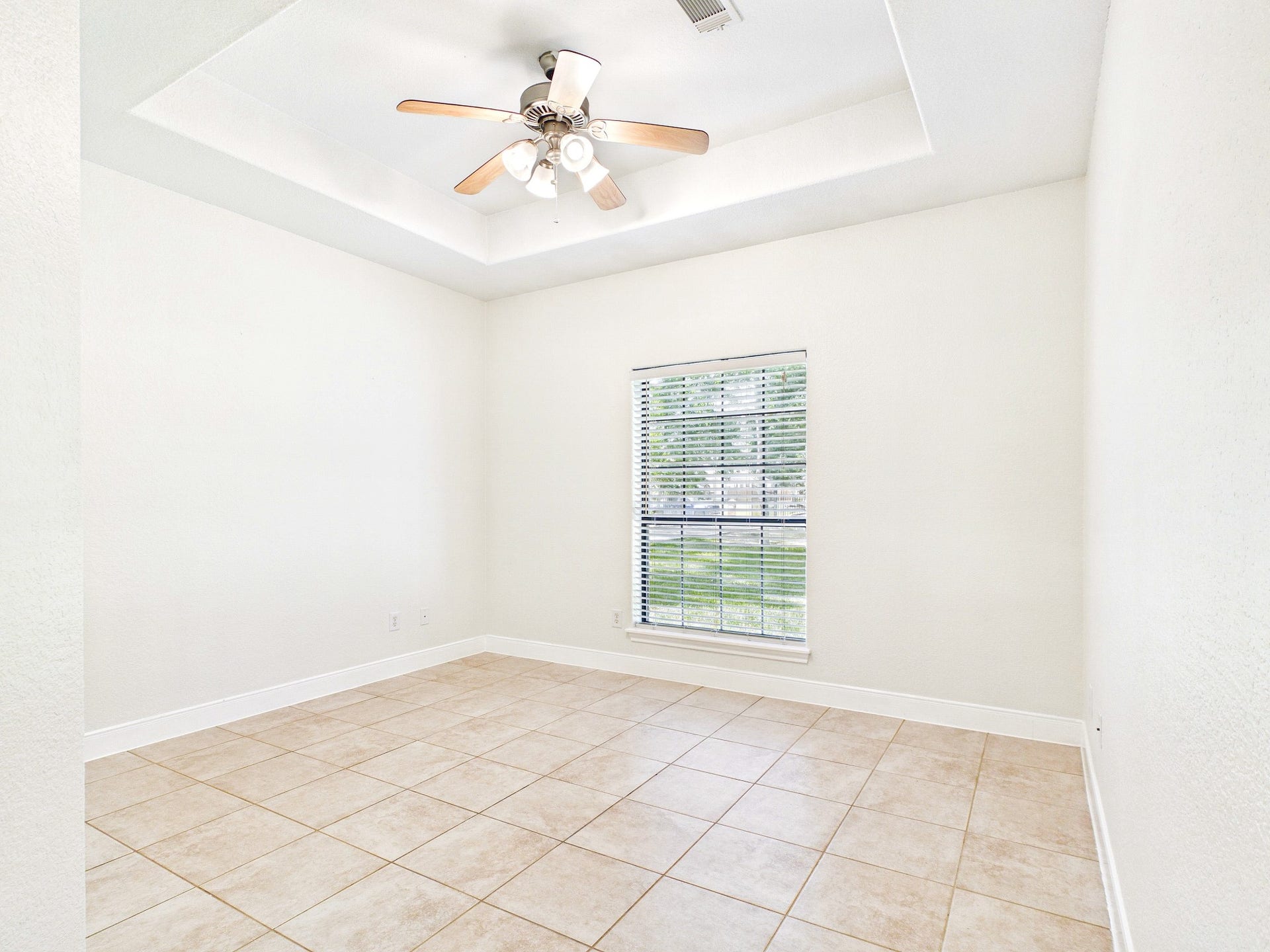 19521 Desna Drive, Porter, TX 77365 Bright, airy bedroom with neutral tile flooring, a ceiling fan, and a large window offering natural light.