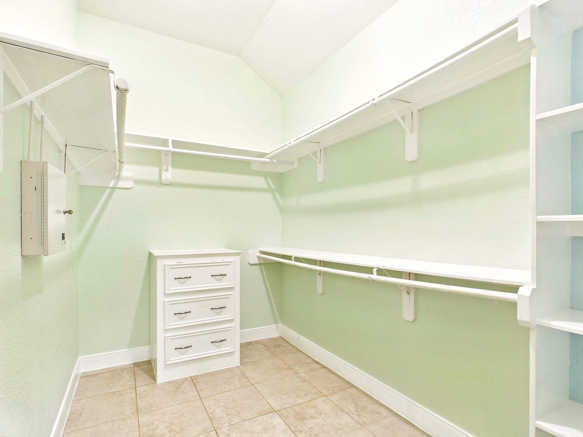 19521 Desna Drive, Porter, TX 77365 This is a spacious walk-in closet located in the primary bedroom with tile flooring, ample shelving, and a set of white drawers. Ideal for organized storage.