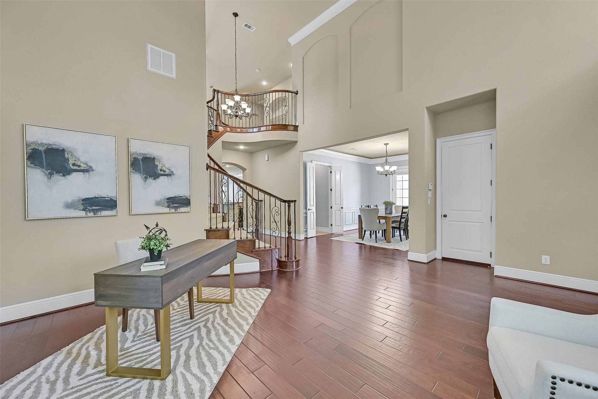 2304 Halls Creek Court, Friendswood, TX 77546 From the formal living room, the homes thoughtful layout begins to unfold with sightlines into the foyer, dining room, and family room beyond. The rounded wall of windows, elevated plant ledge, and expansive wood flooring make this space feel both grand and inviting.