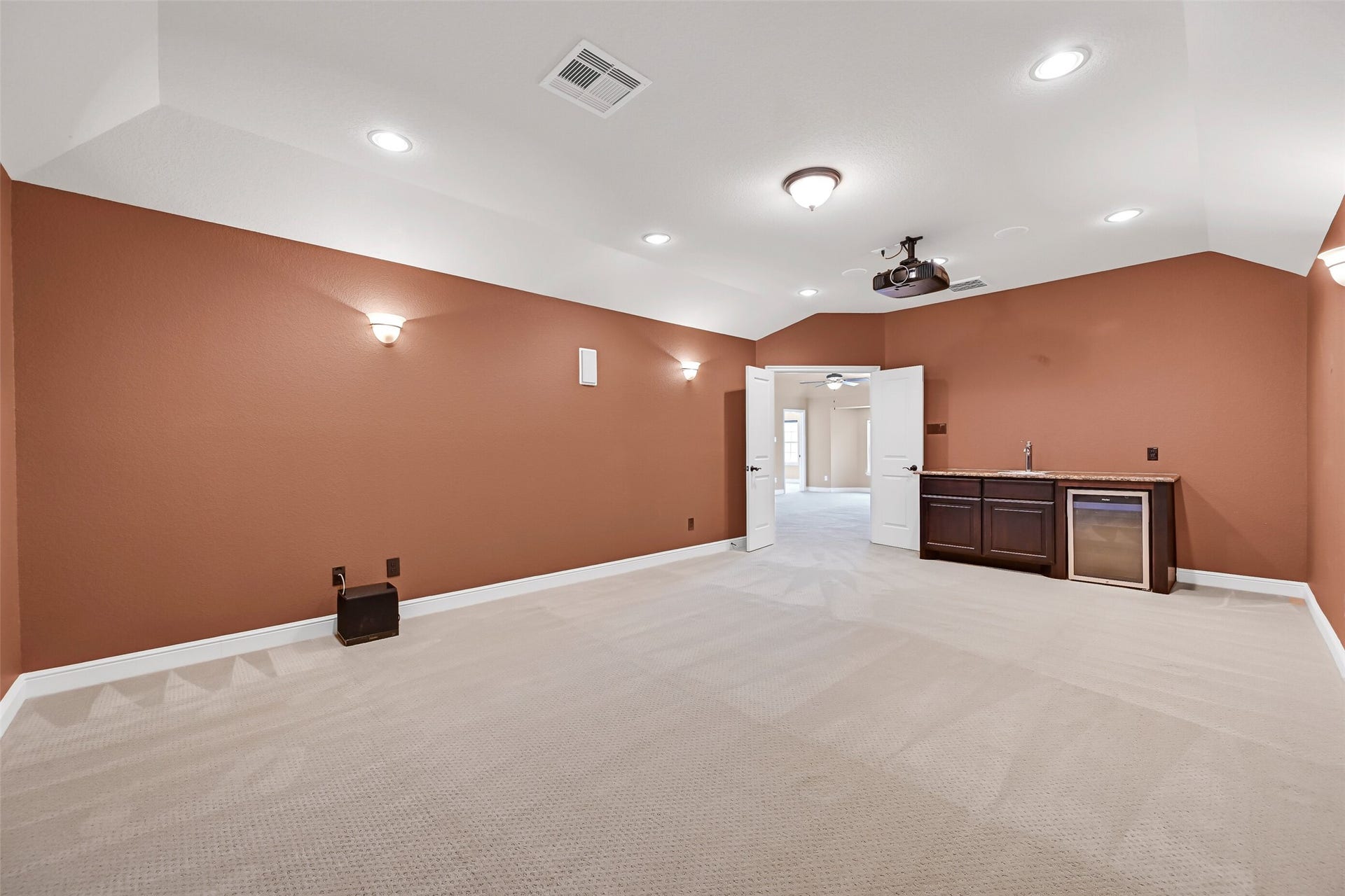 2304 Halls Creek Court, Friendswood, TX 77546 This spacious media room also includes a convenient wet bar with granite countertops, cabinetry, a beverage fridge, and room for snacks and drinks, making it ideal for hosting movie marathons or game day watch parties.