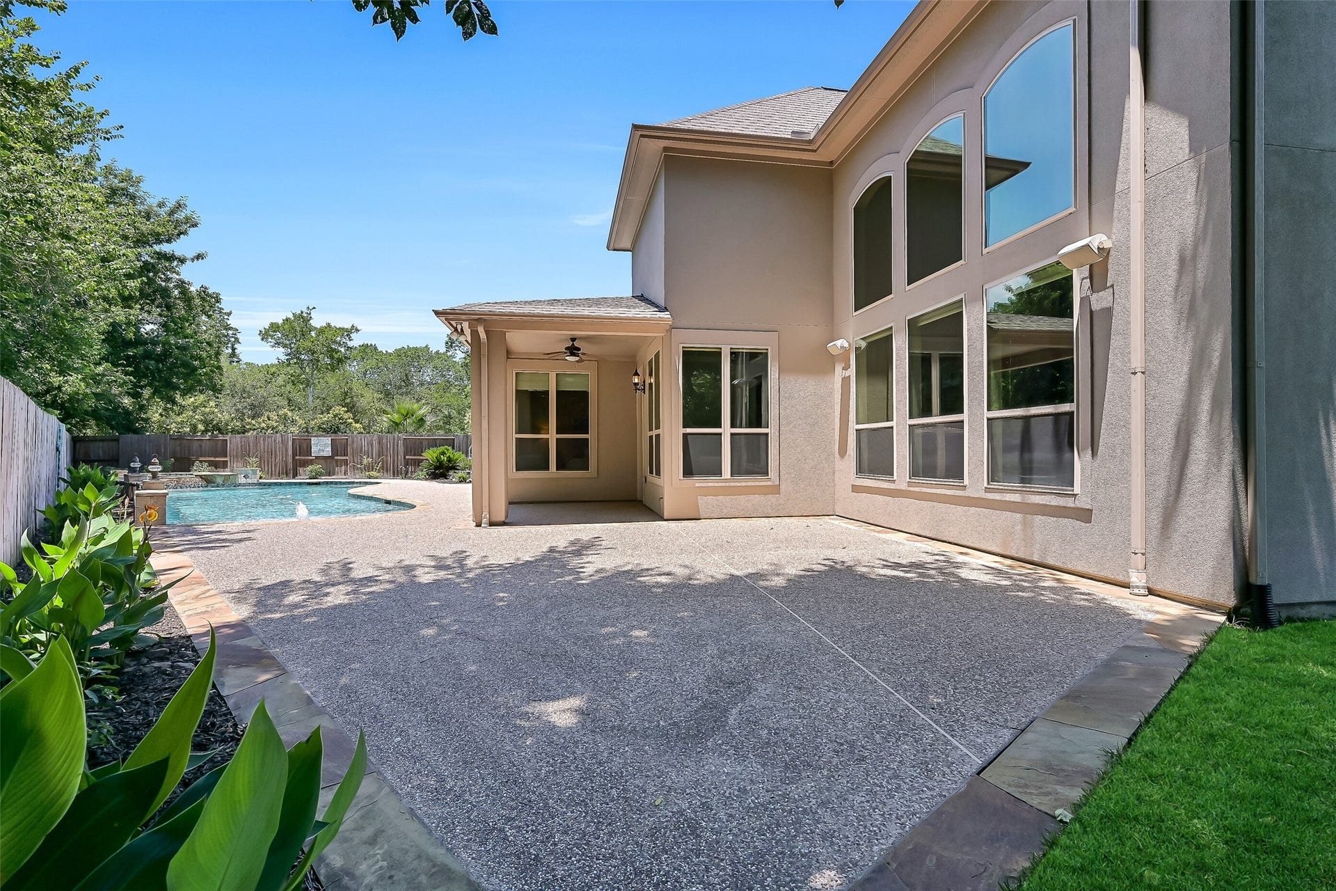 2304 Halls Creek Court, Friendswood, TX 77546 The backyard offers extensive patio space for lounging, dining, and entertaining, with the covered patio positioned perfectly to enjoy views of the pool and surrounding greenery.