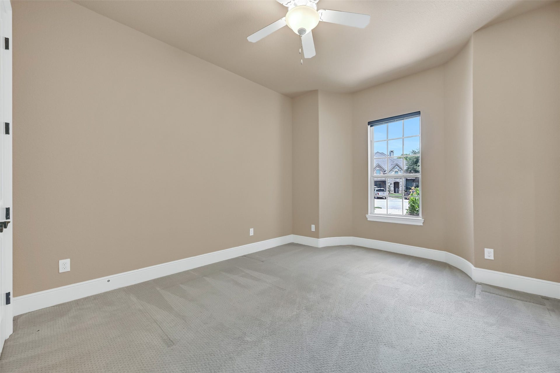 2304 Halls Creek Court, Friendswood, TX 77546 Privately situated on the first floor, this secondary guest suite offers plush sculpted carpet, soft natural light, a lighted ceiling fan, and a quiet front-facing location that works beautifully for overnight guests, multigenerational living, or a private home office.