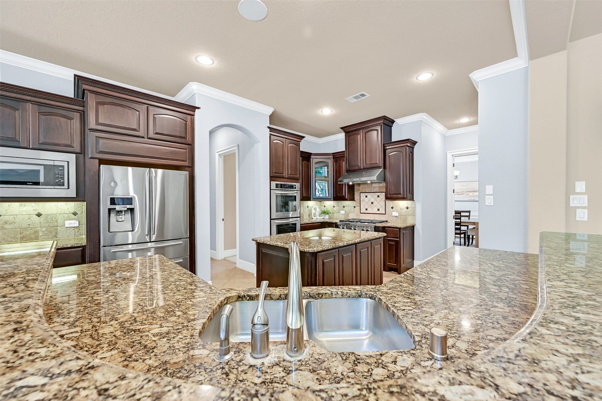 2304 Halls Creek Court, Friendswood, TX 77546 From the sink, you can overlook both the family room and breakfast area while preparing meals, making the kitchen feel connected to the entire home. Granite counters, a deep basin sink, and extensive prep space surround the central island for effortless everyday living and entertaining.