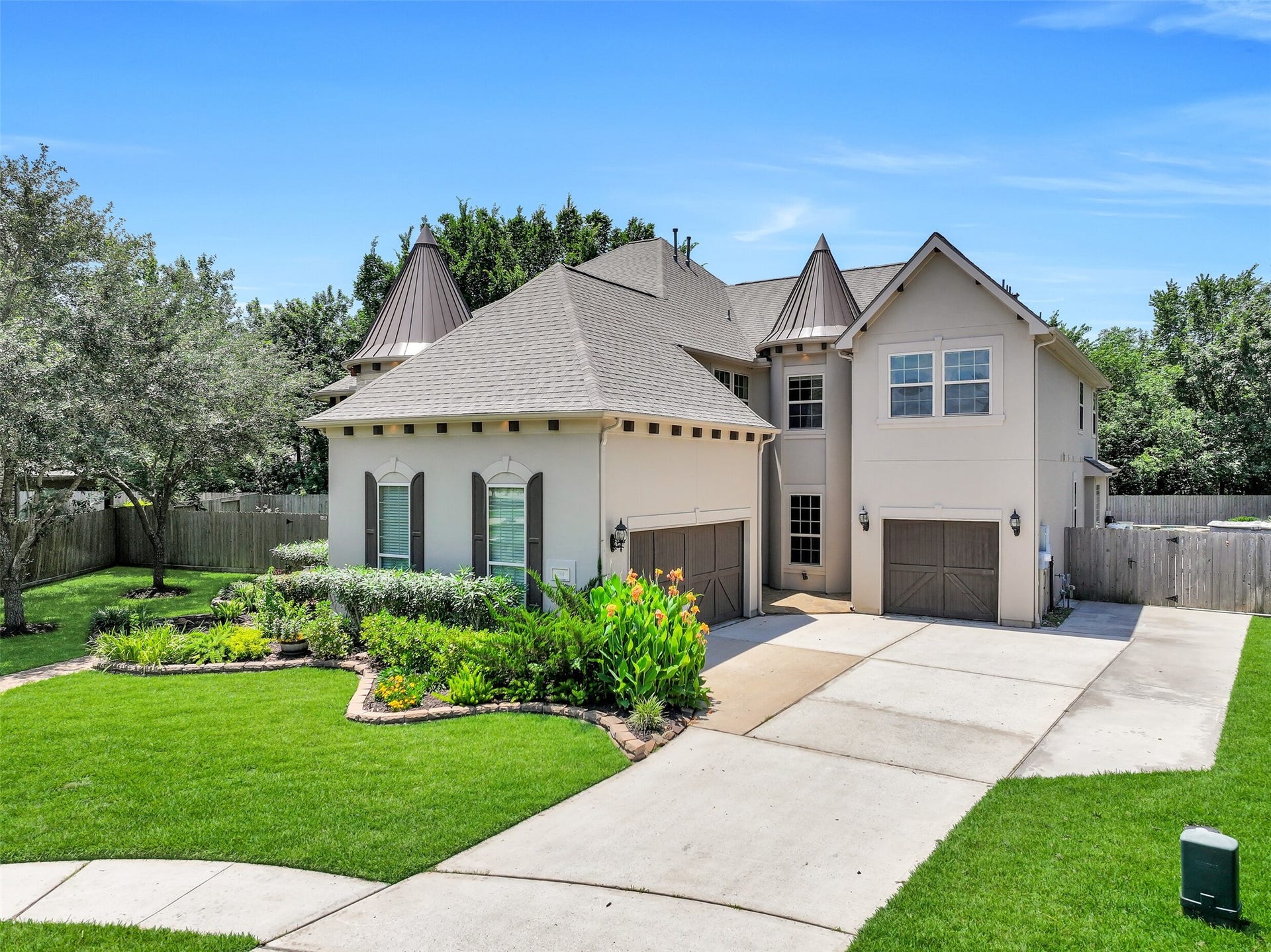 2304 Halls Creek Court, Friendswood, TX 77546 From the extended double-wide driveway to the separate single and two-car garage bays, every detail of the exterior was thoughtfully designed for both function and architectural impact. The all-stucco faade, mature landscaping, sprinkler system, and distinctive turret rooflines give the home a timeless, estate-style presence.