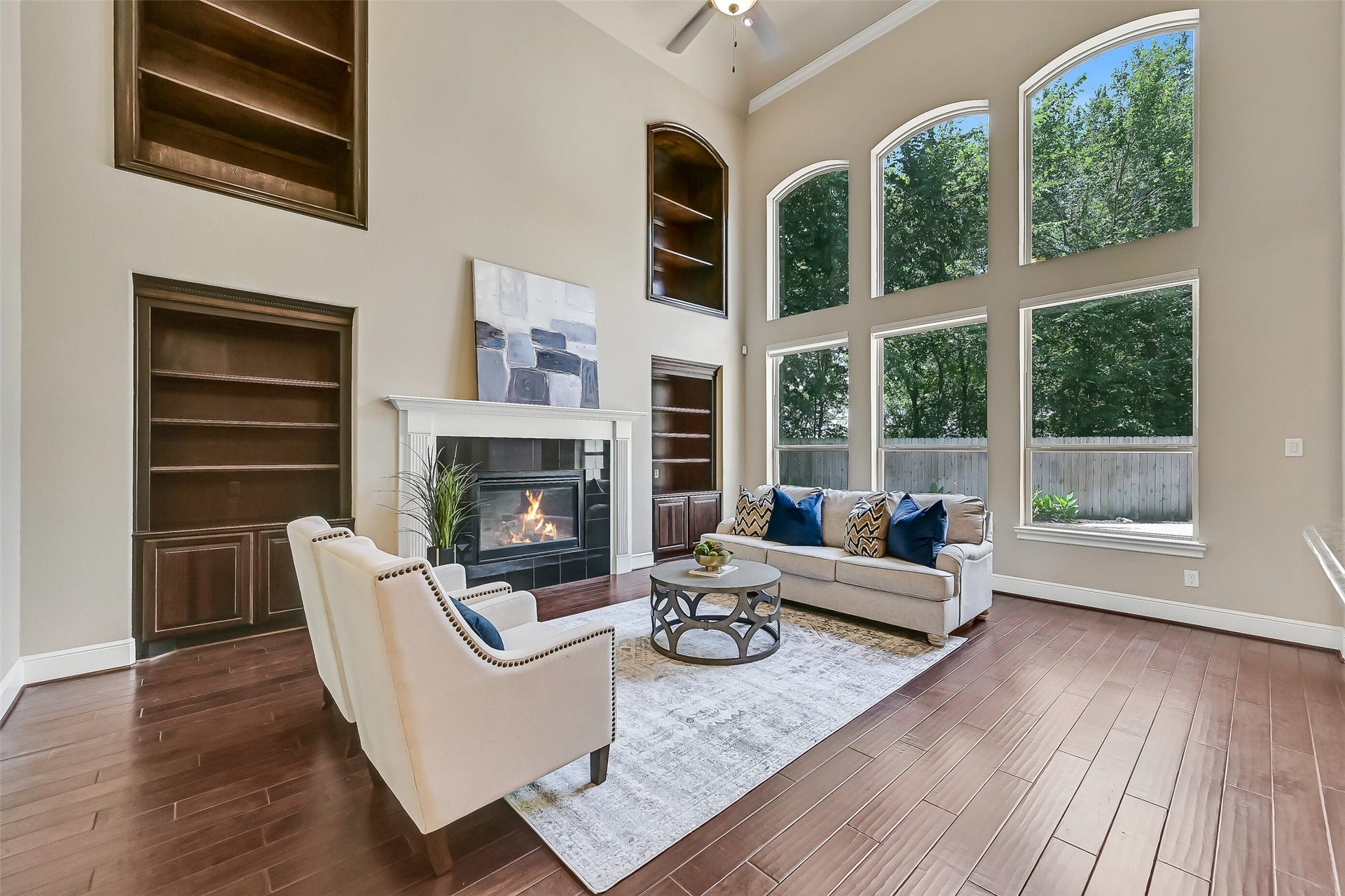 2304 Halls Creek Court, Friendswood, TX 77546 Another view of the family room highlights the incredible natural light and soaring vertical scale of the space, with oversized windows framing peaceful backyard views and creating a seamless connection between the indoor living areas and outdoor entertaining spaces beyond.