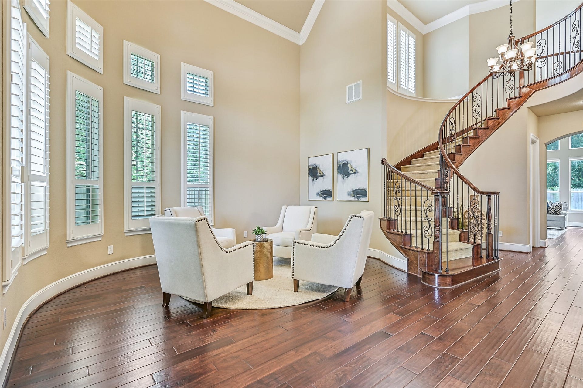 2304 Halls Creek Court, Friendswood, TX 77546 The sweeping staircase becomes a true focal point of the entry with sculpted carpet treads, richly stained woodwork, and intricate iron detailing, all framed by 20-foot ceilings and oversized windows that create an airy, open feel from the moment you walk in.