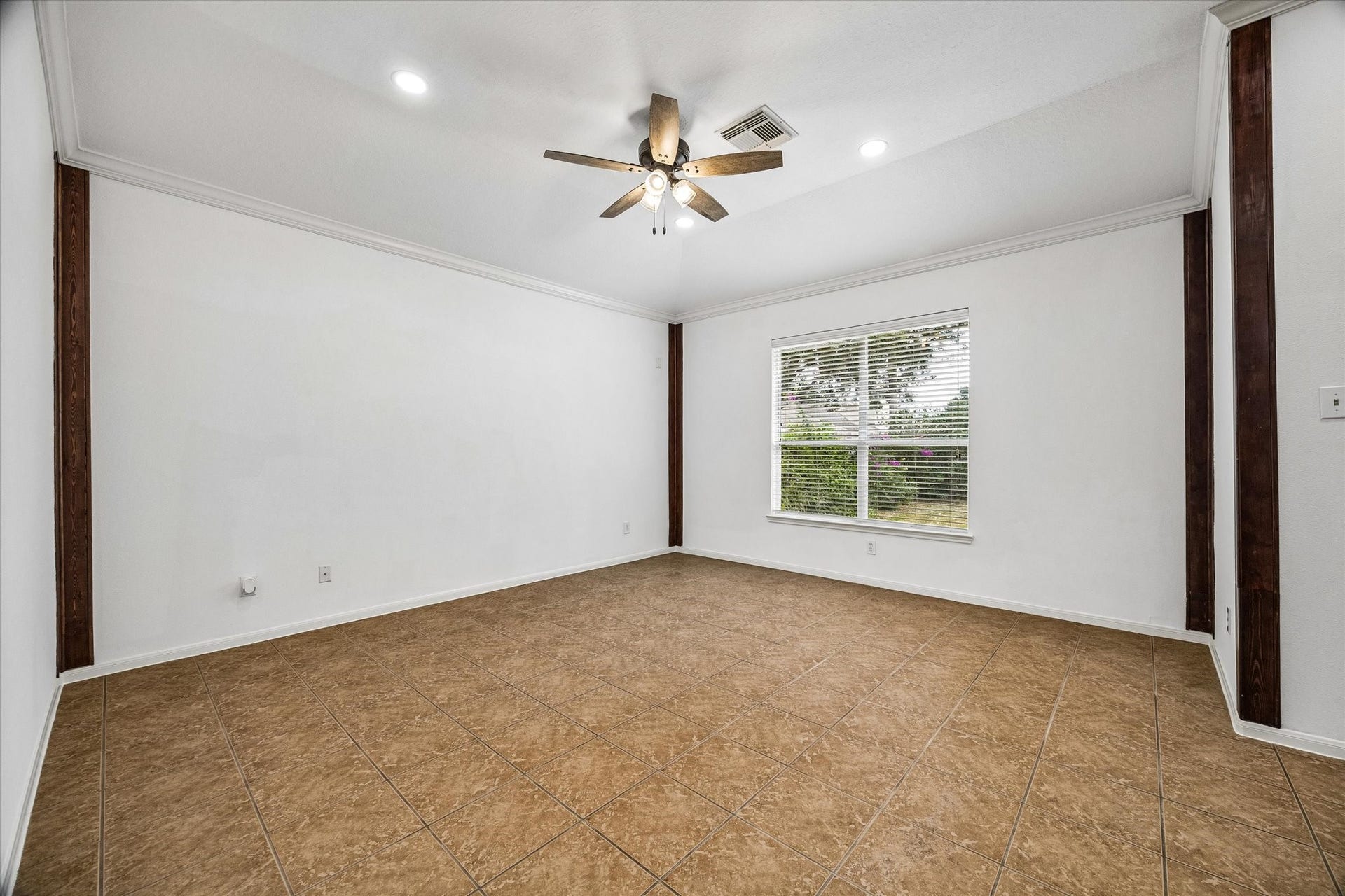 6741 Hidden Colony Lane, Dickinson, TX 77539 Spacious room featuring elegant tile flooring, a modern ceiling fan, and ample natural light through a large window, perfect for versatile living.
