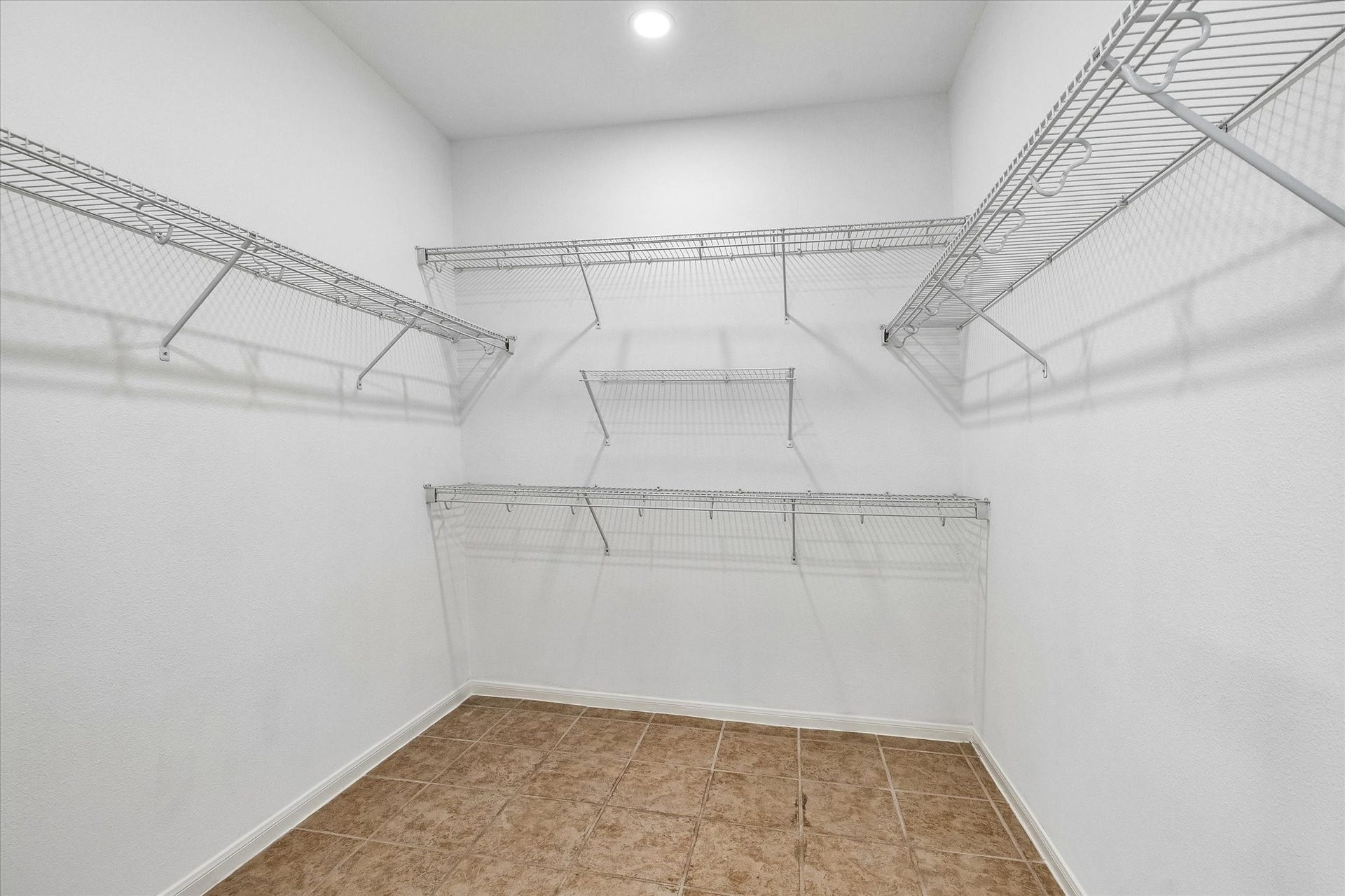 6741 Hidden Colony Lane, Dickinson, TX 77539 Spacious walk-in closet featuring sleek built-in shelves for effortless organization.