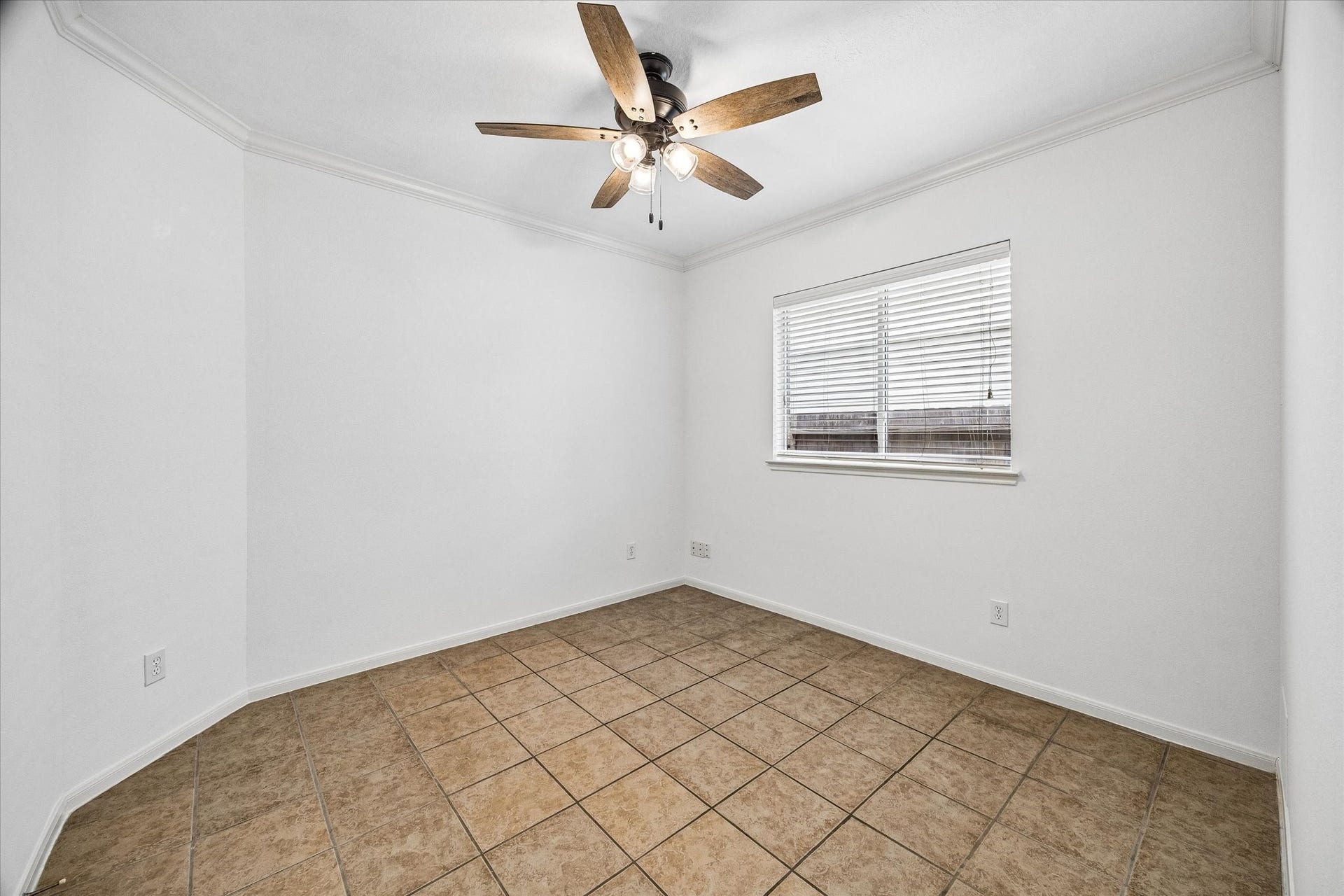 6741 Hidden Colony Lane, Dickinson, TX 77539 Bright and inviting room featuring neutral tile flooring, a ceiling fan, and ample natural light from a well-placed window. Perfect for versatile use.