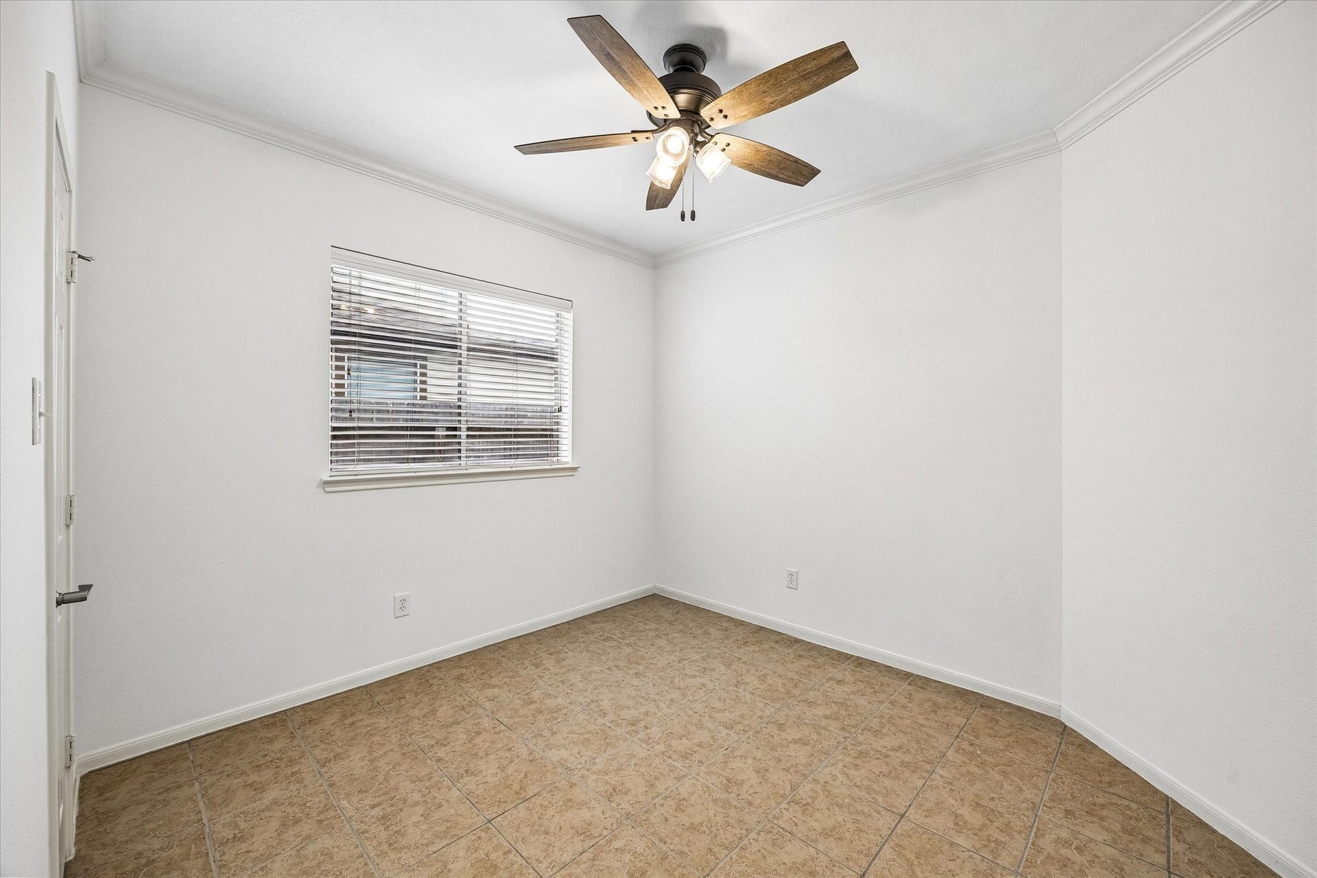 6741 Hidden Colony Lane, Dickinson, TX 77539 Bright and airy second guest bedroom featuring neutral tile flooring, a ceiling fan with lights, and a window with blinds, perfect for versatile use.