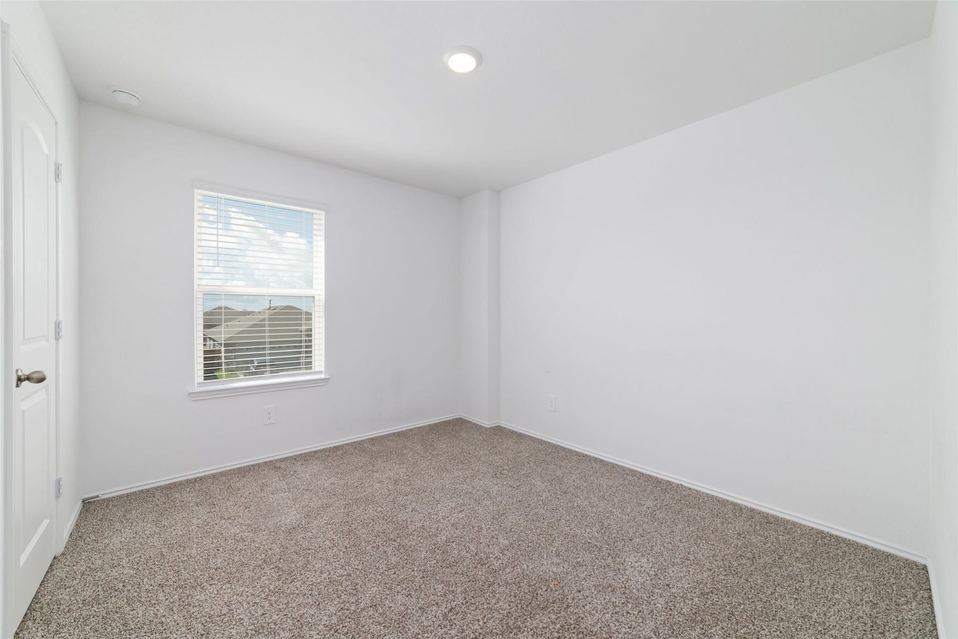 (Upstairs Bedroom 4): This inviting, move-in-ready upstairs bedroom mirrors the home's fresh, barely-lived-in aesthetic with spotless white interiors and plush, clean carpeting. Positioned to overlook the front of the home, the room features a large picture window with built-in blinds, offering great natural lighting and easy access to the adjacent game room and upstairs full bathroom
