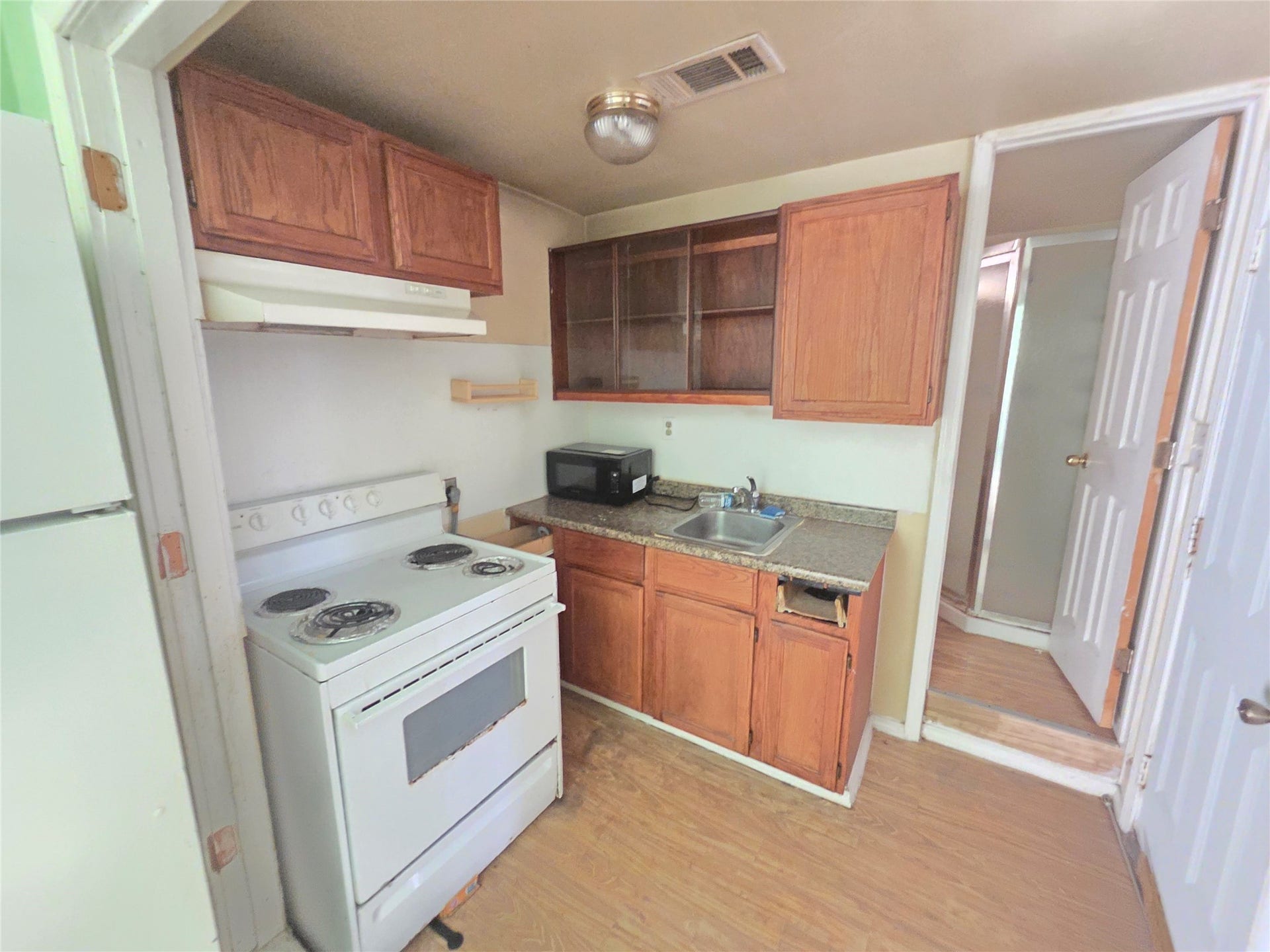 View of full kitchen in studio apartment.