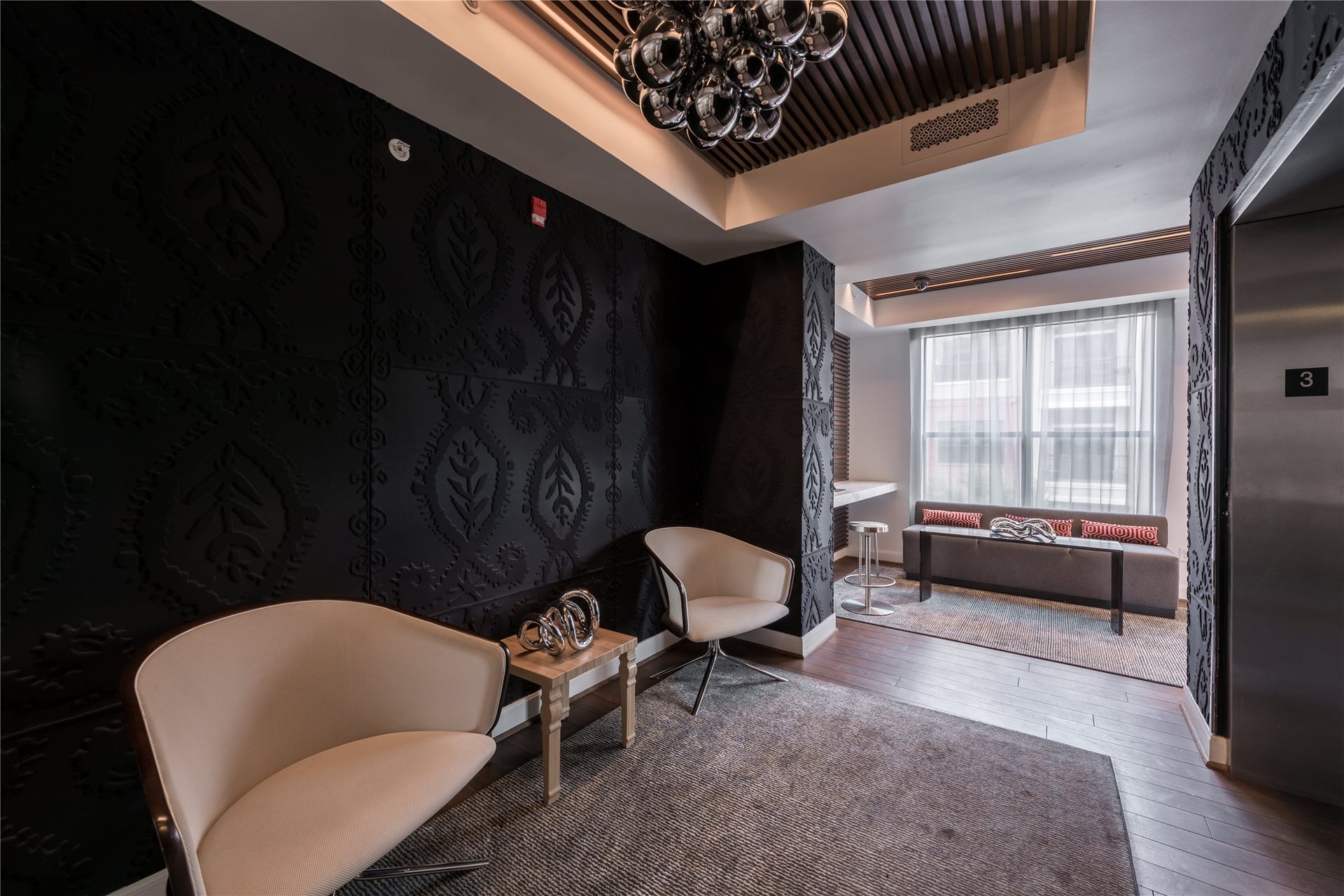 Elegant elevator lobby featuring dramatic textured walls, designer lighting, and sophisticated seating areas. Thoughtful architectural details and contemporary finishes create a stylish welcome for residents and guests.