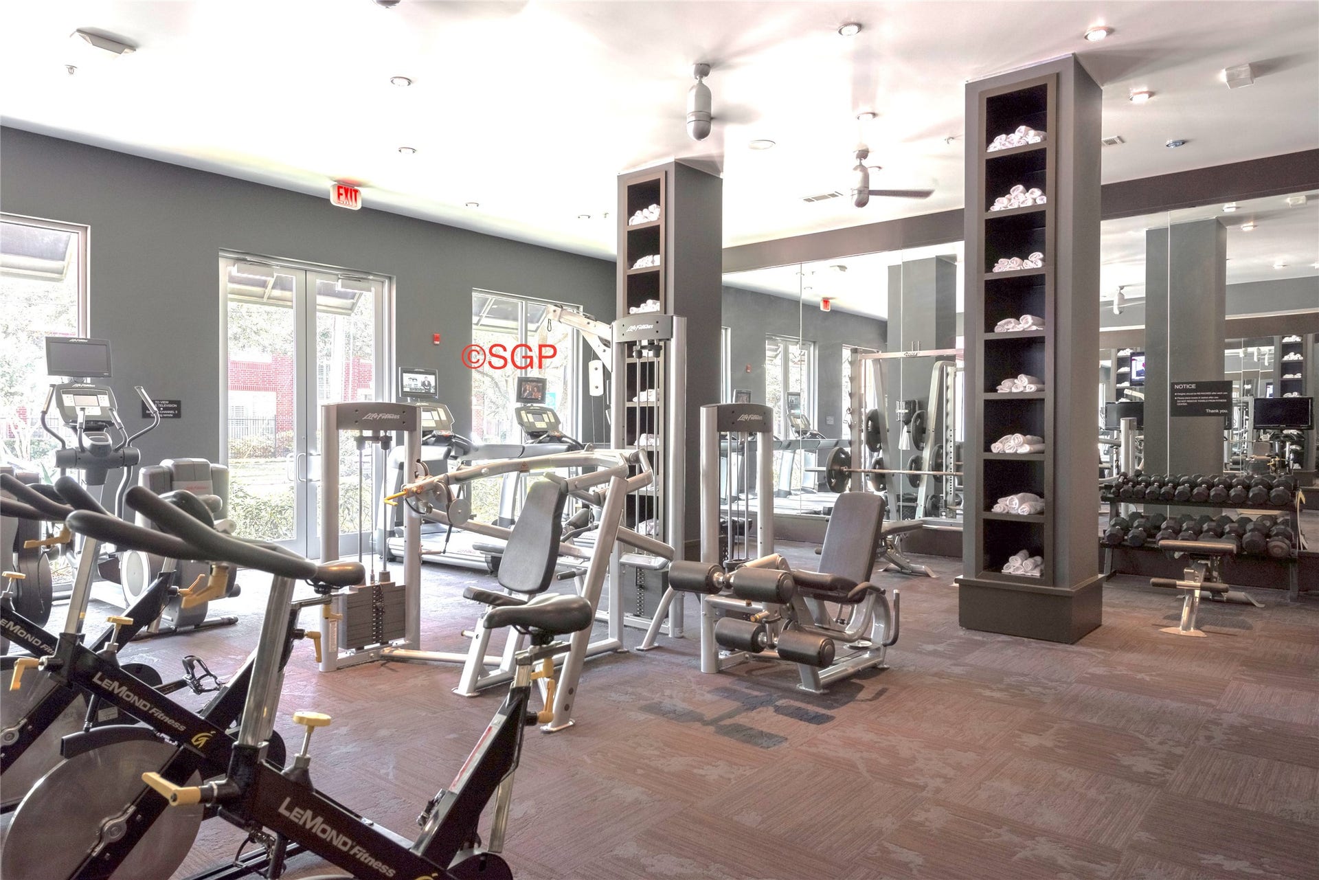 State-of-the-art fitness center featuring cardio and strength-training equipment, free weights, and dedicated cycling stations. Expansive windows and mirrored walls create a bright, spacious environment for residents to enjoy.